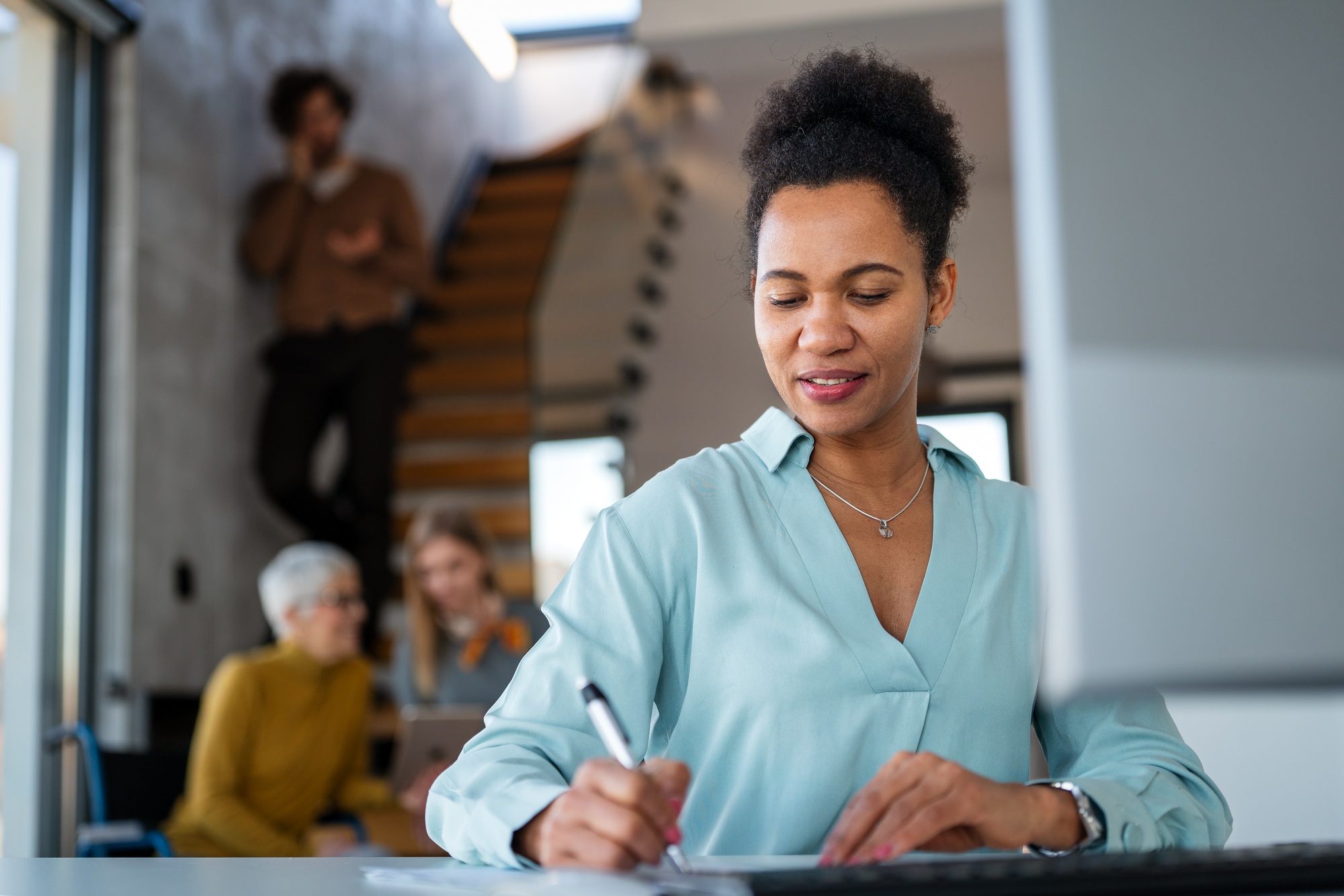 Manager woman sitting at a desk in creative office working on computer in marketing agency.