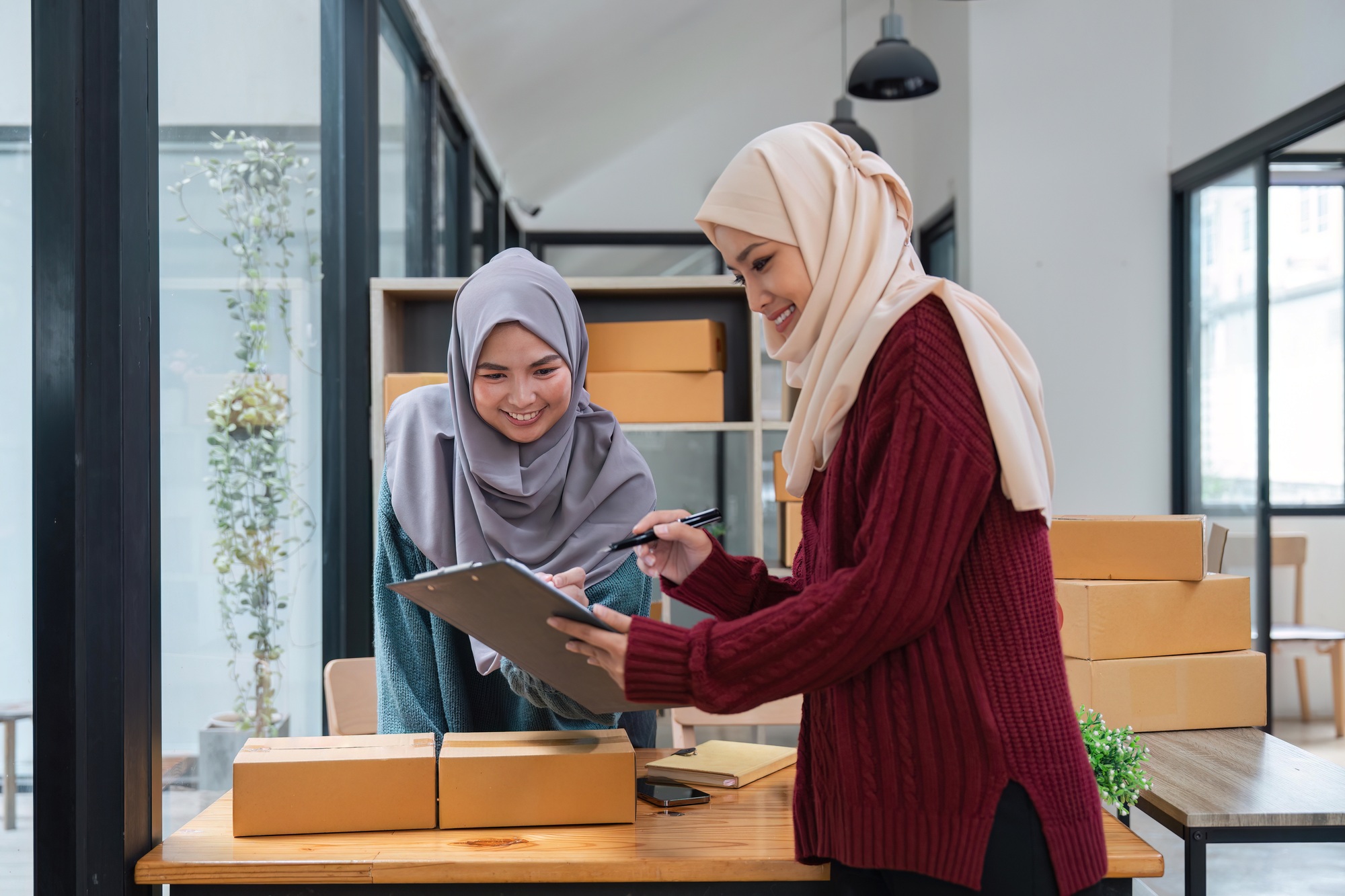 Muslim two woman freelancer sme business online shopping working on laptop computer and checklist