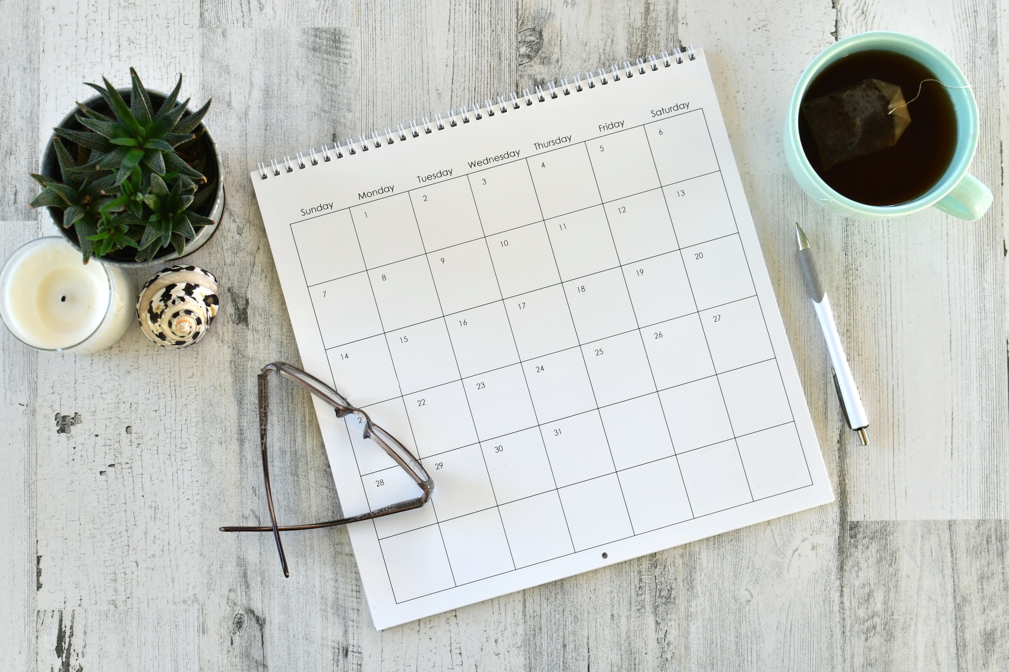 Overhead flat lay view of calendar, scheduling work personal appointments - blank no year