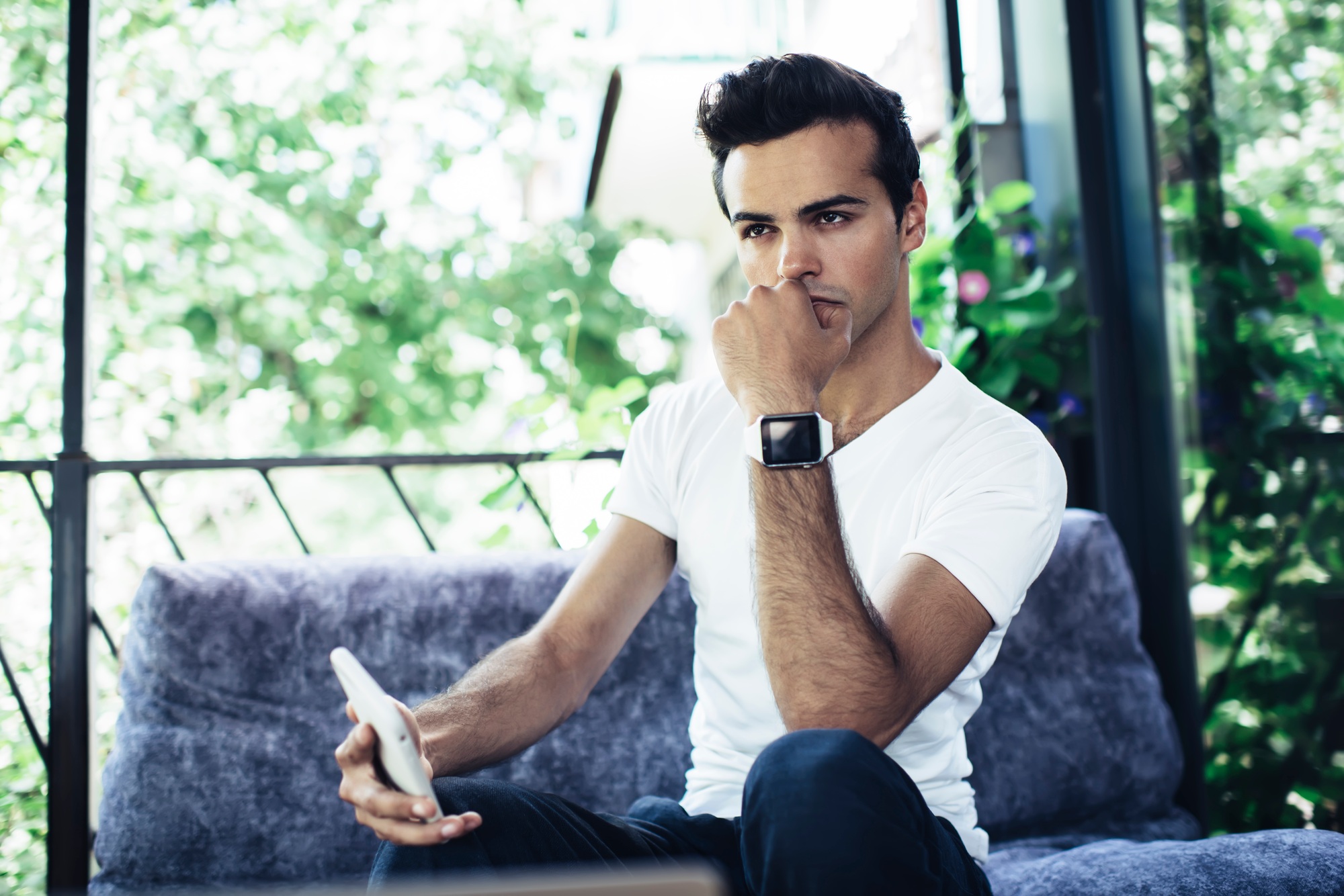 Pensive man with digital cellphone technology thinking about content for network publication