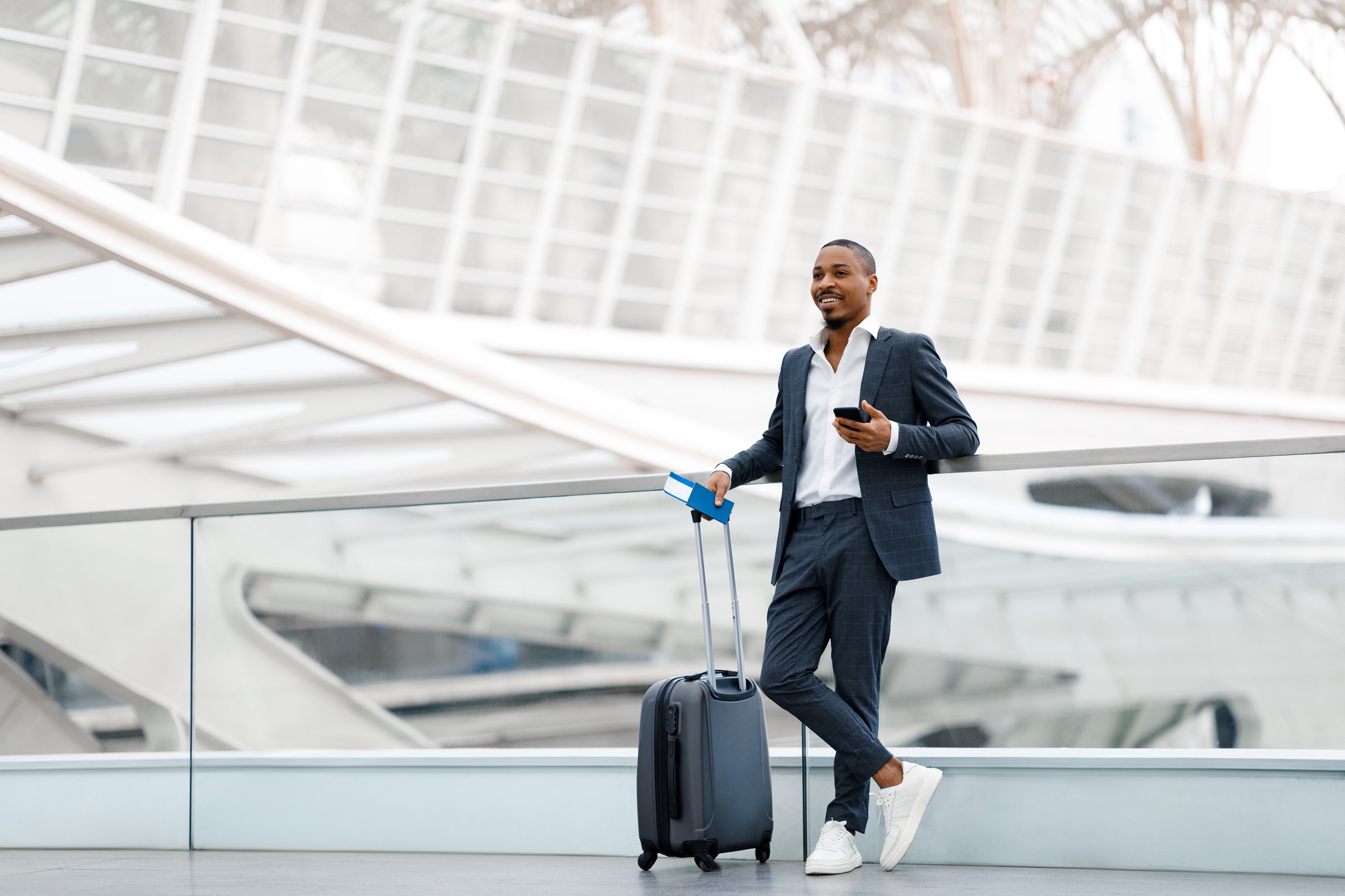 Portrait Of Handsome Black Business Man Standing With Suitcase At Airport Terminal