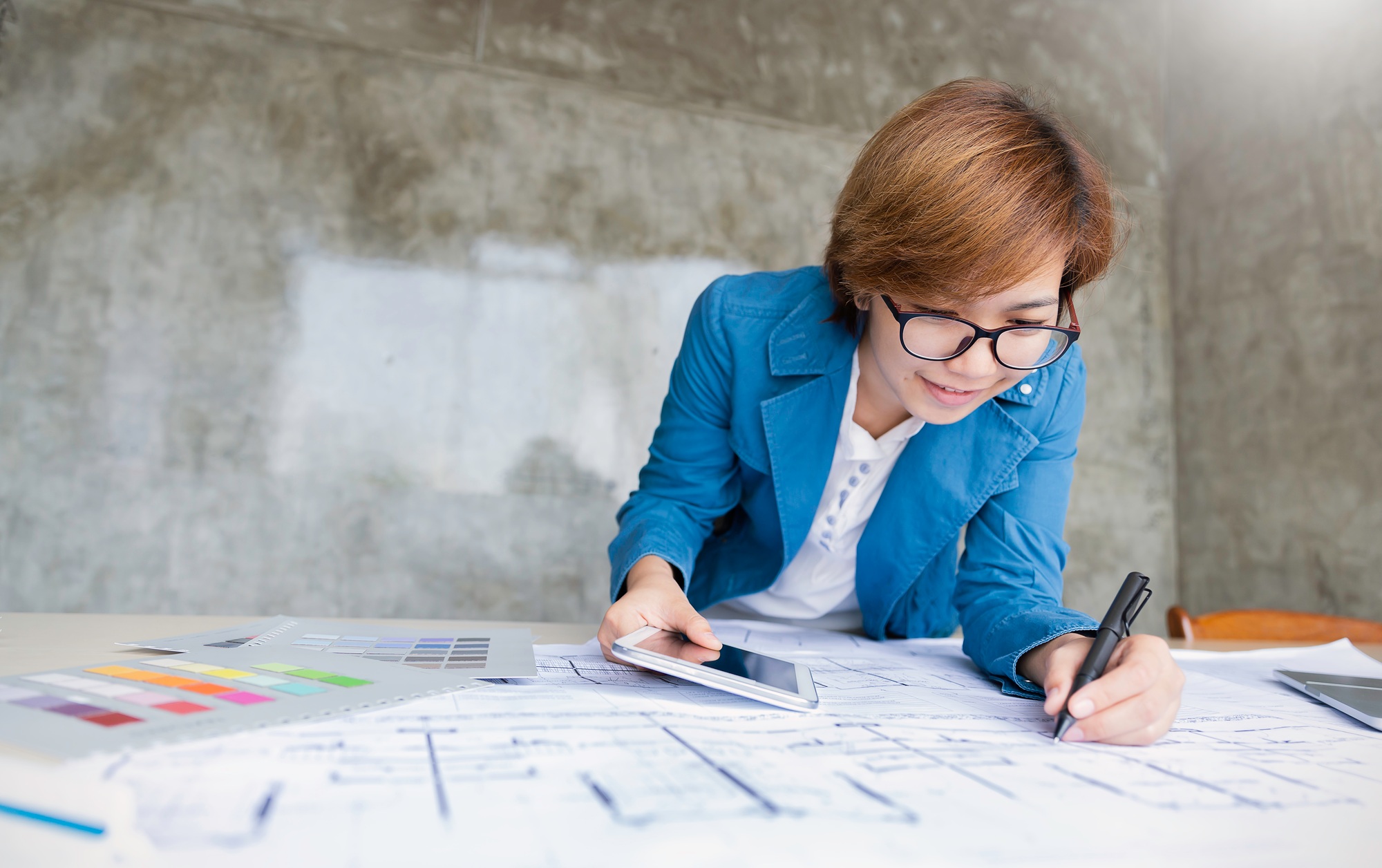 Portrait of young designer business woman designing layout. Business prototype house sketch plan
