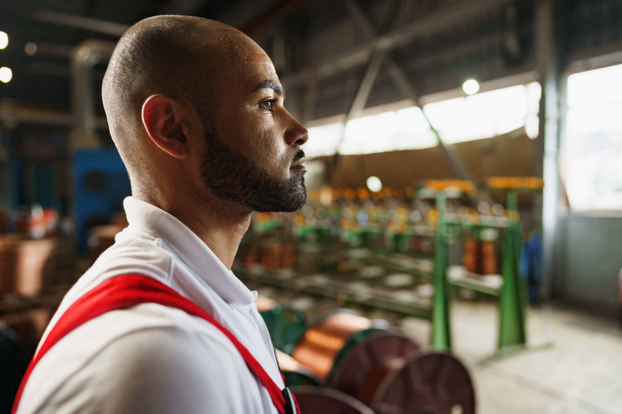 Profile photo of young african american handyman working in a factory