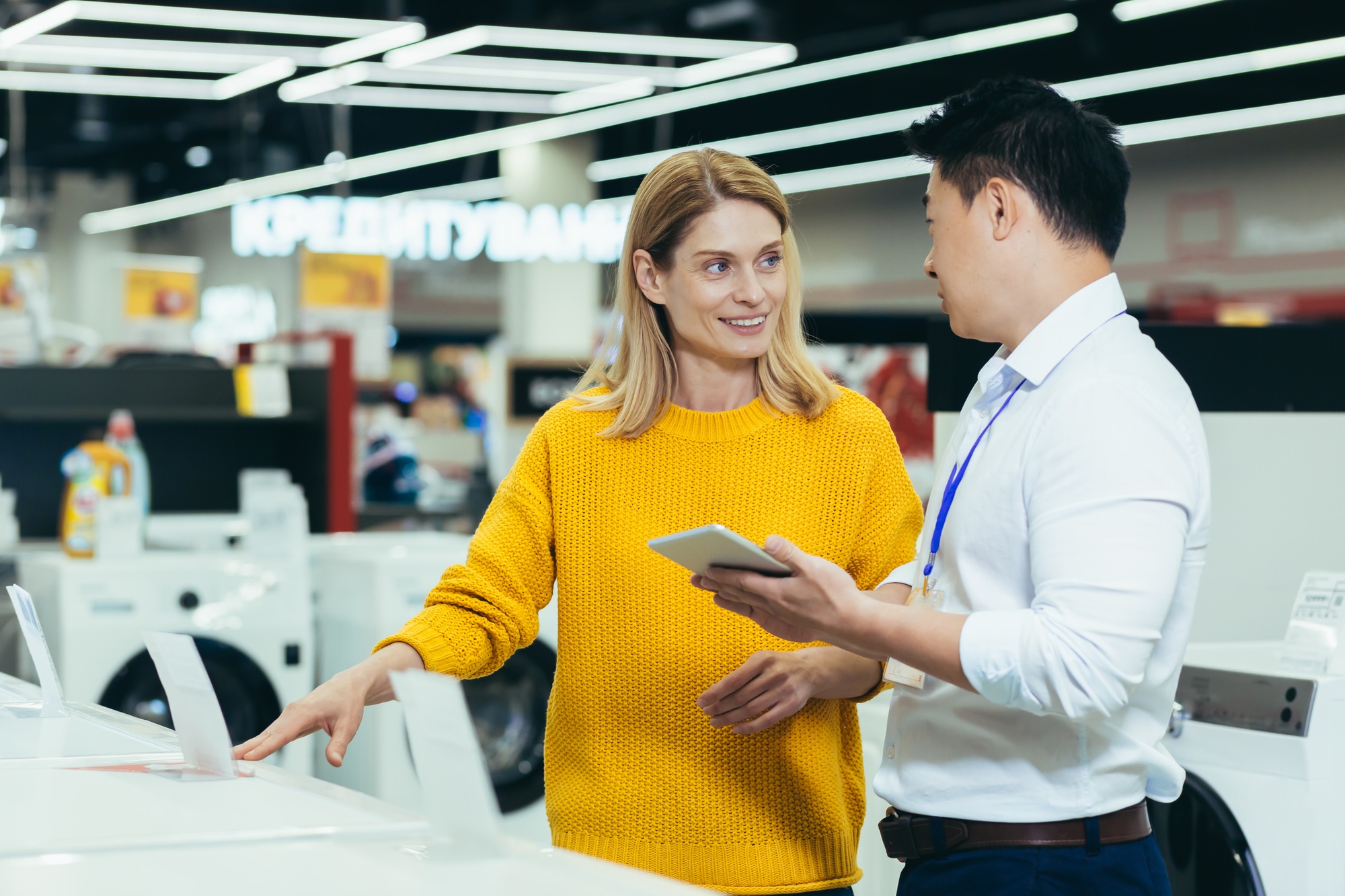 Asian consultant salesman in electronics and household appliances store, selling