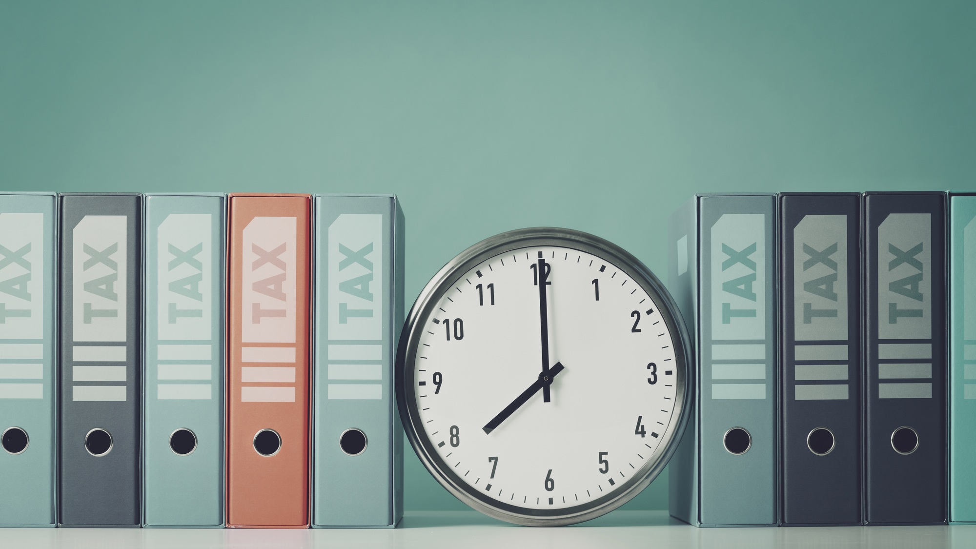 Ring binders containing tax documents and clock