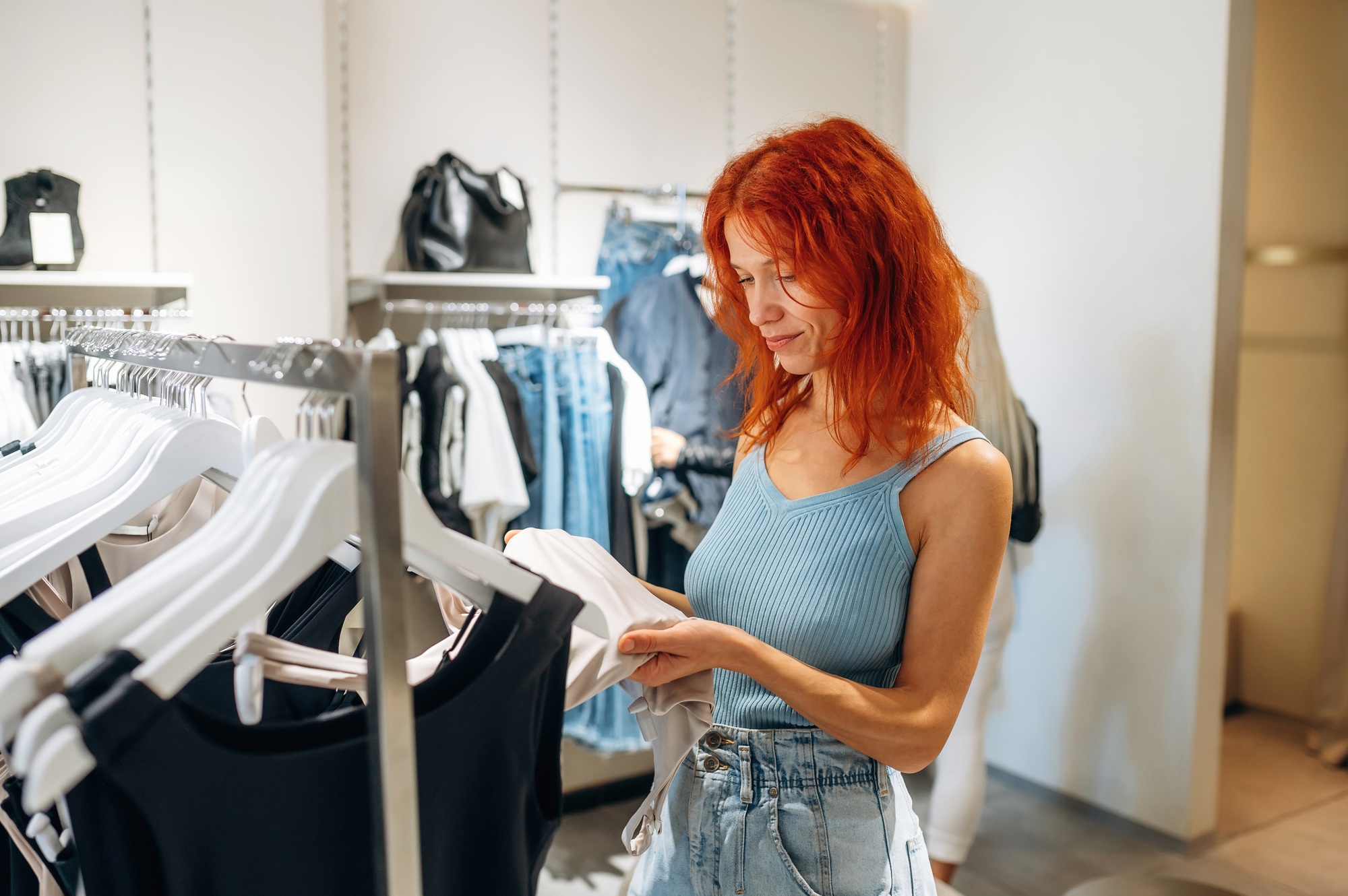 Simple but beautiful design. Woman chooses clothes in retail store