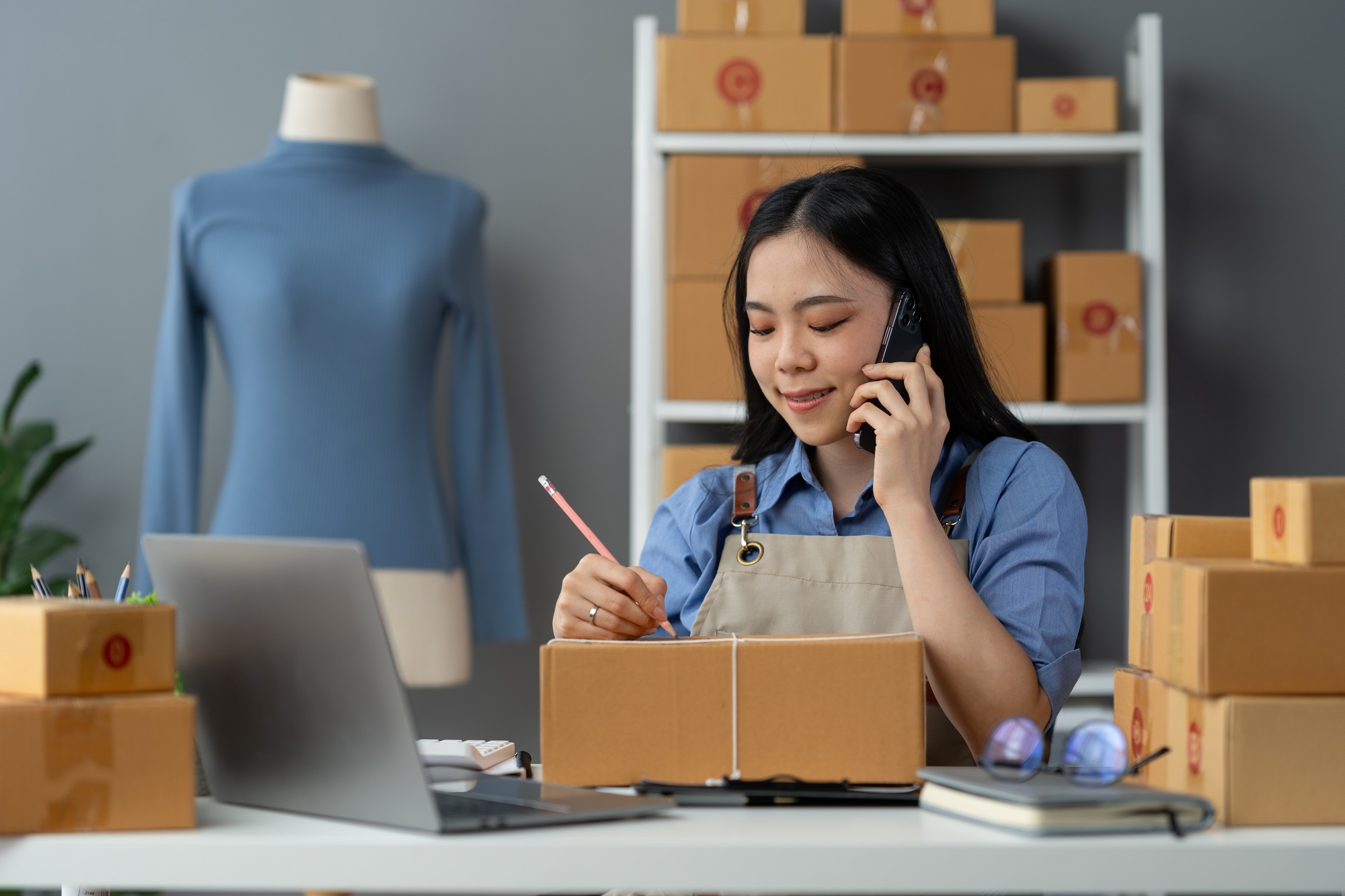 Small business entrepreneur SME freelance woman using phone call receive from customer checking prod