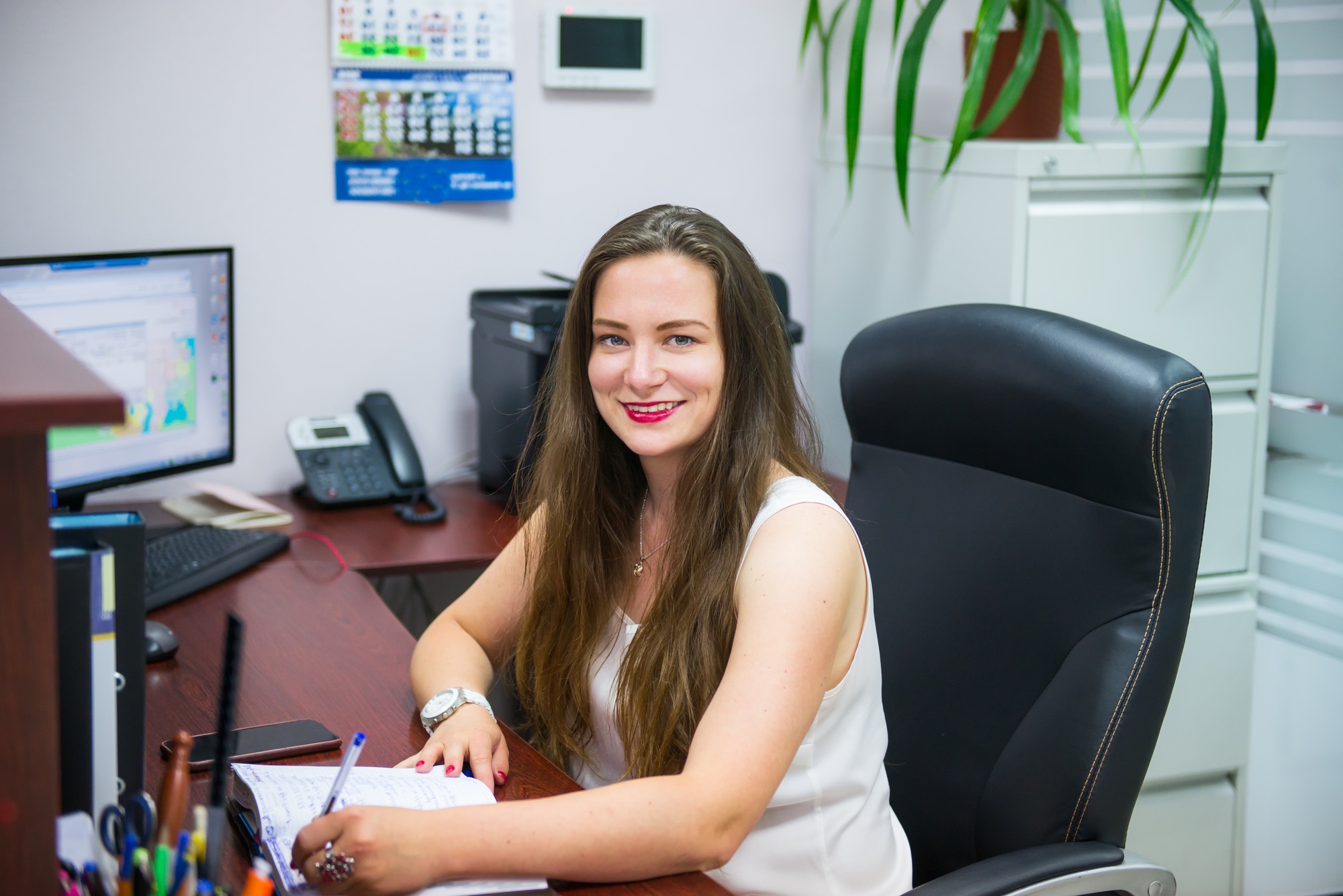 Smiling business lady sitting on the workplace in office. Female entrepreneurship. skilled manager
