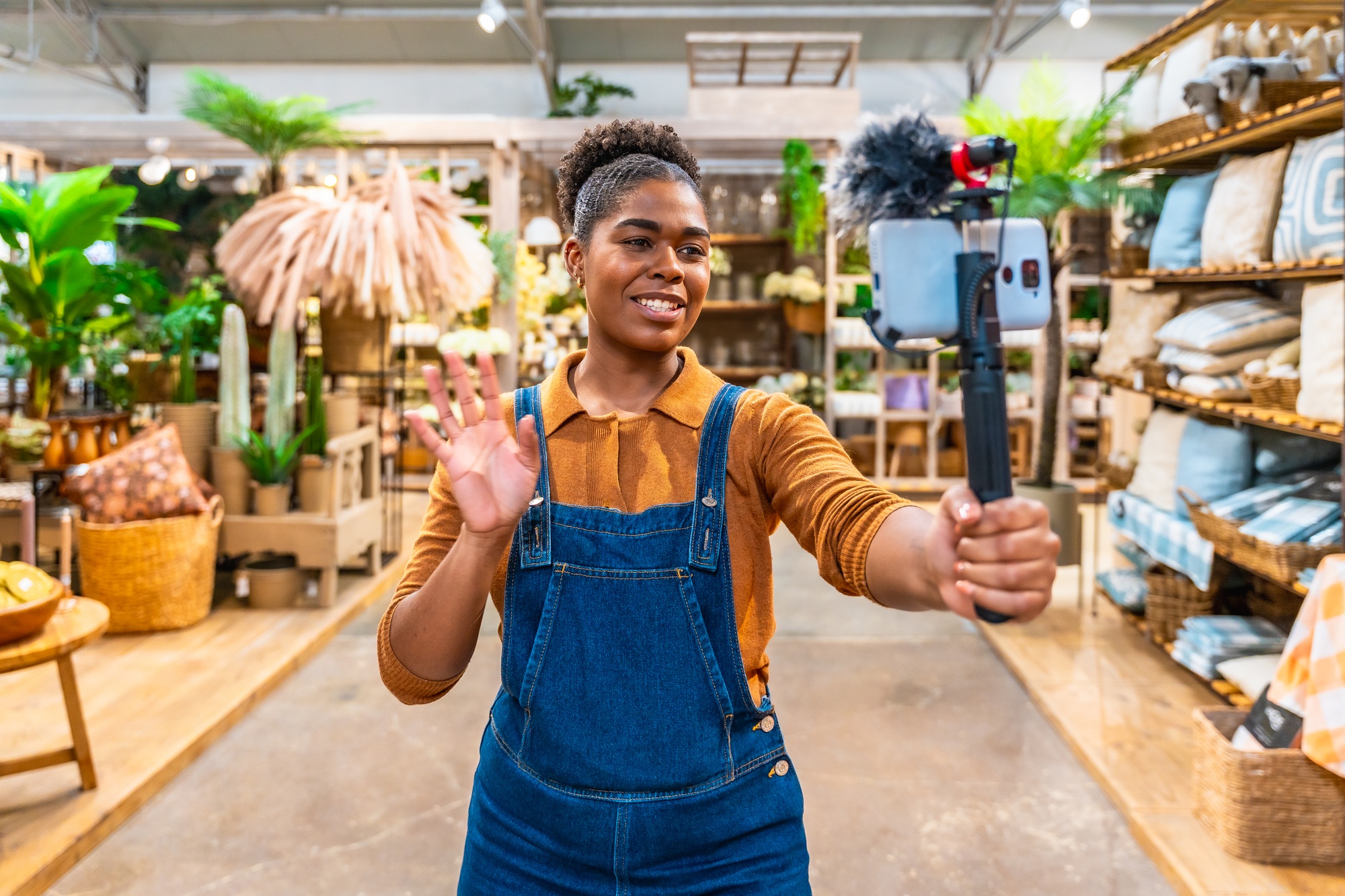 Smiling saleswoman streaming live in furniture store with smartphone