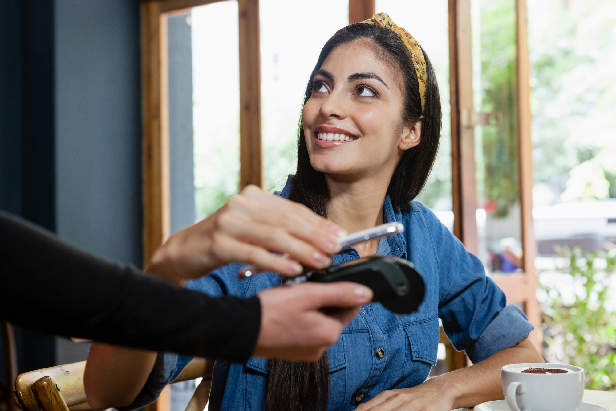 Smiling woman making payment on credit card reader