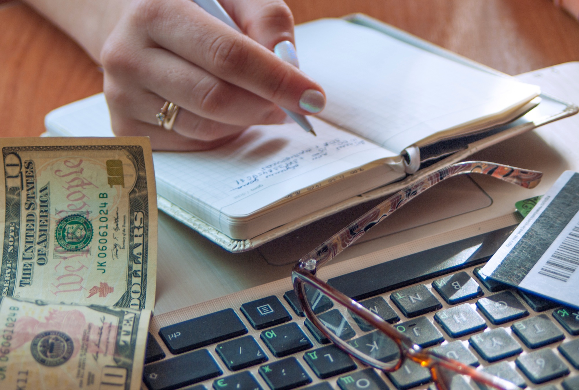 the girl counts the money and makes notes in the notebook,