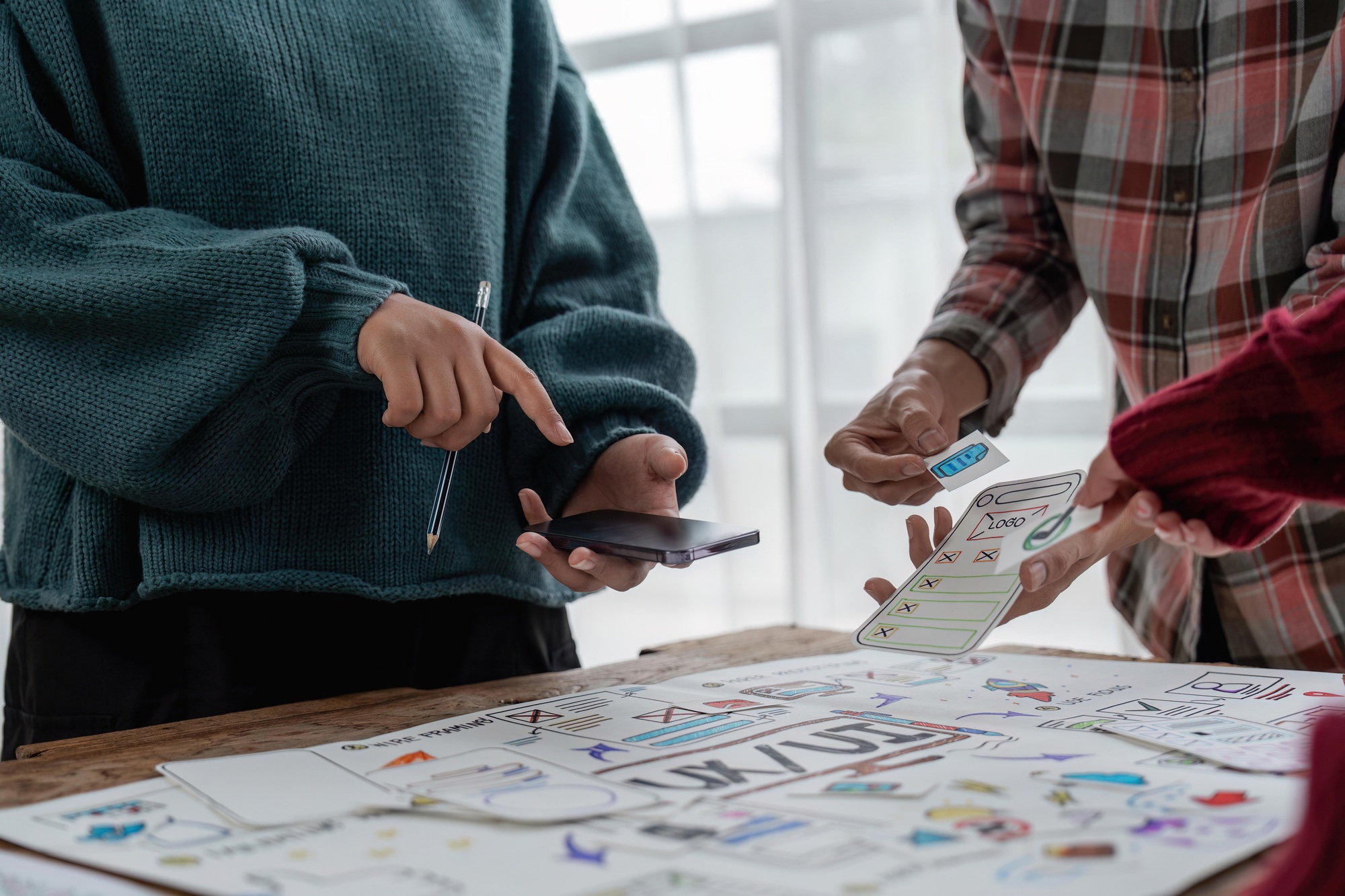 The web designer team is helping to design applications for mobile phones. UX UI designer concept