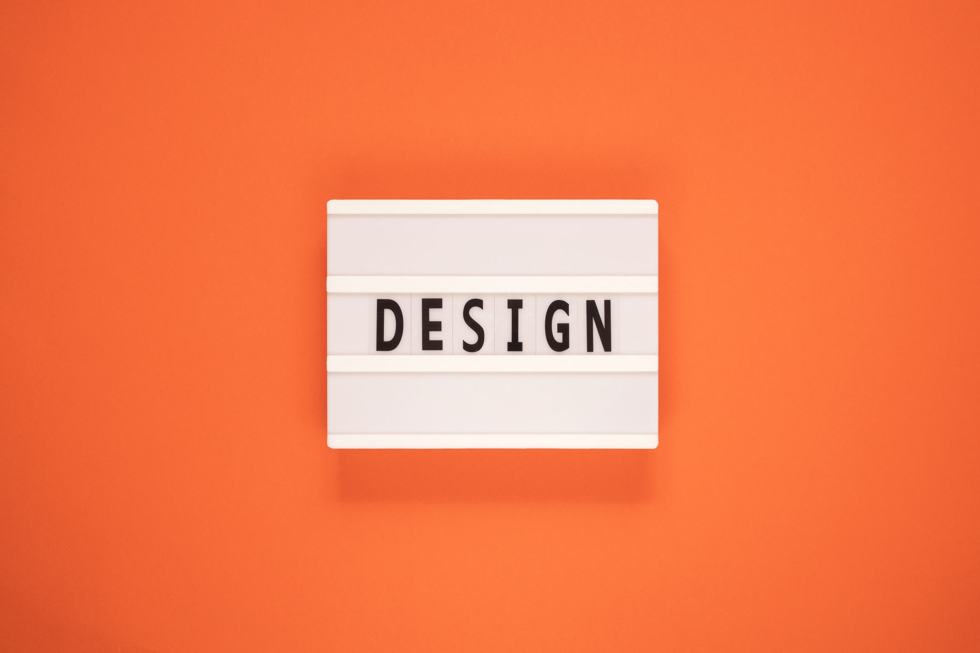 The word design on lightbox isolated orange background