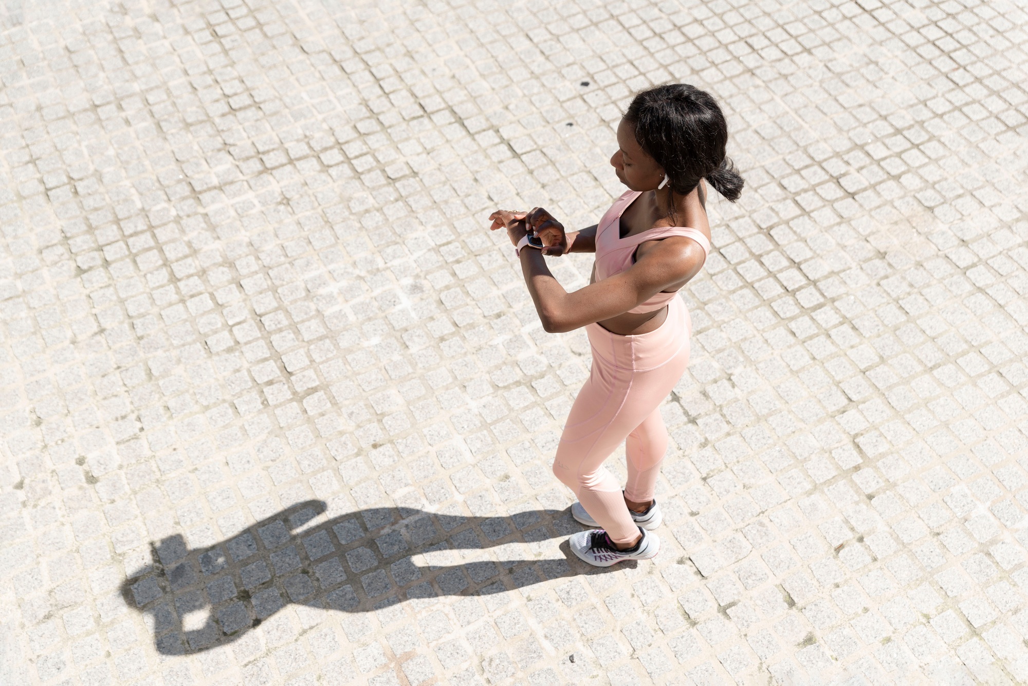 Top view of a young African American woman checking progress on the smart watch.