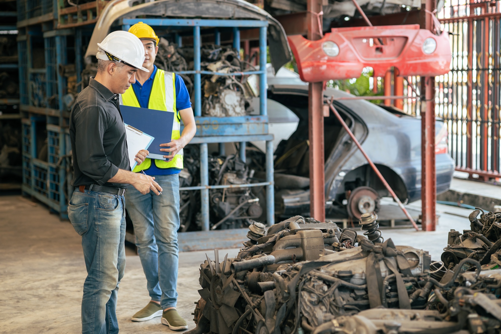 used car part business owner working check stock order with young technician