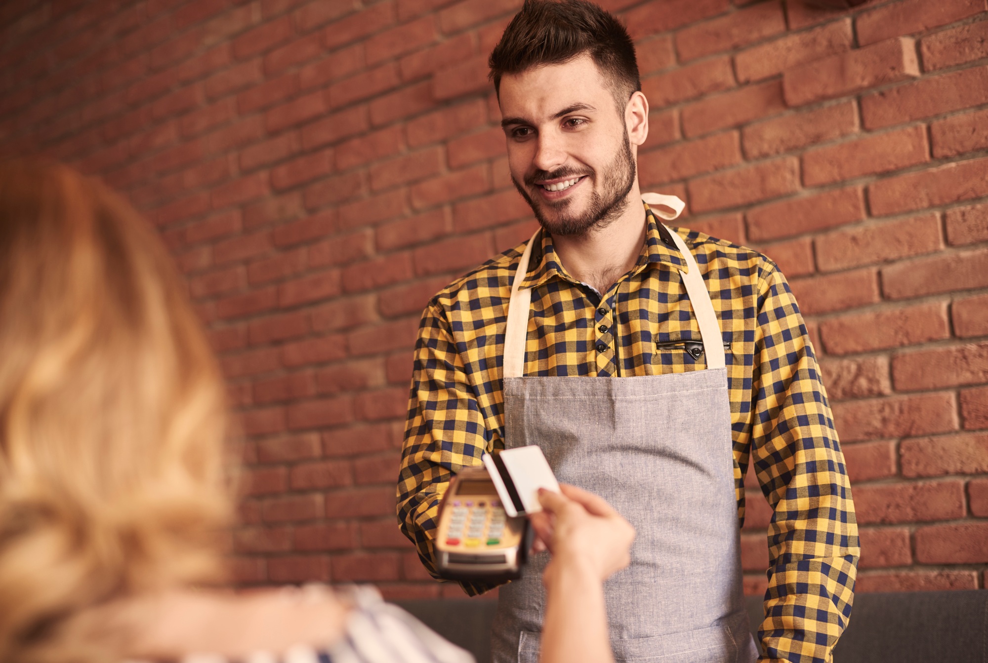 Waiter with credit card reader waiting for payment