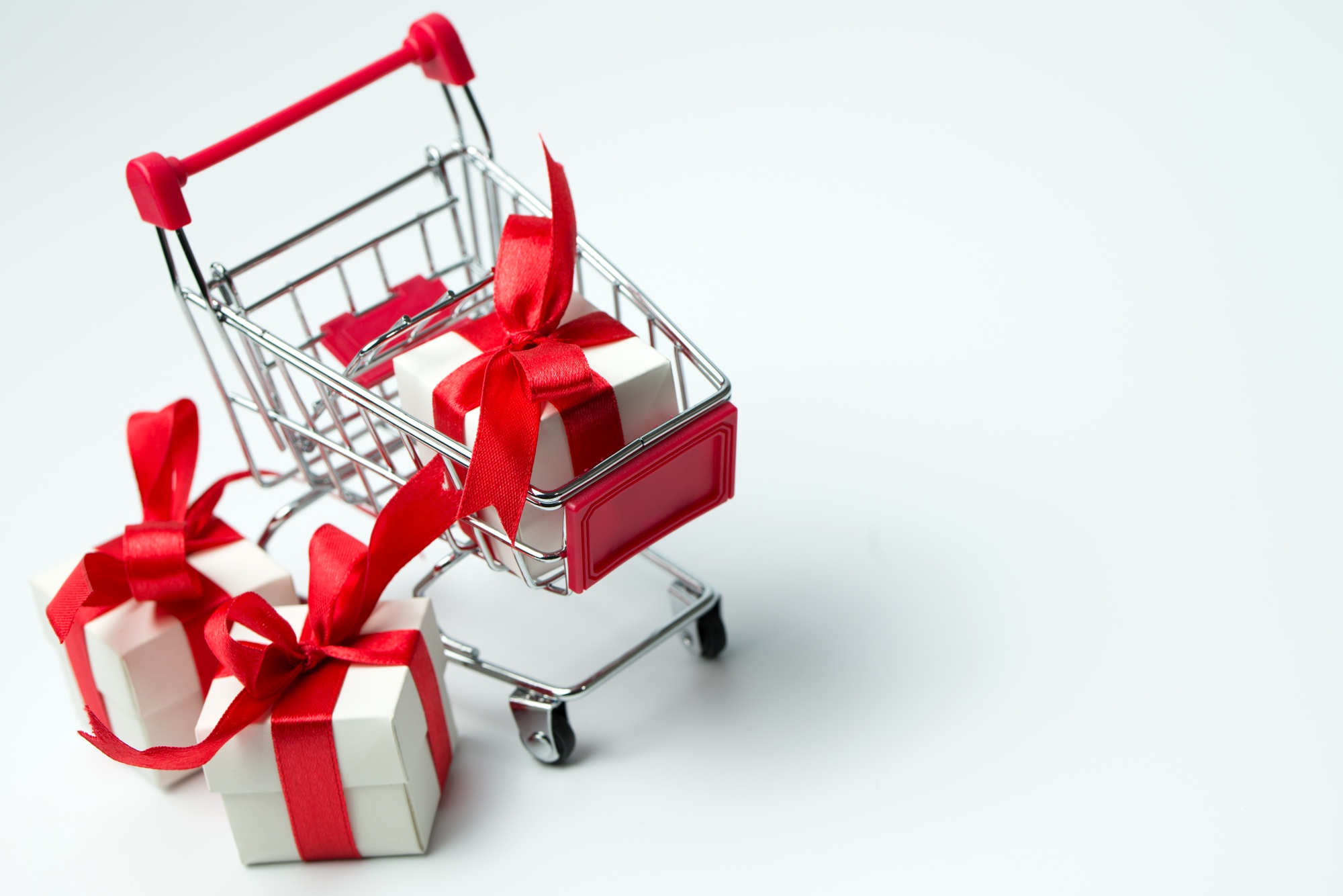 White gift box tied with red ribbon in a shopping cart