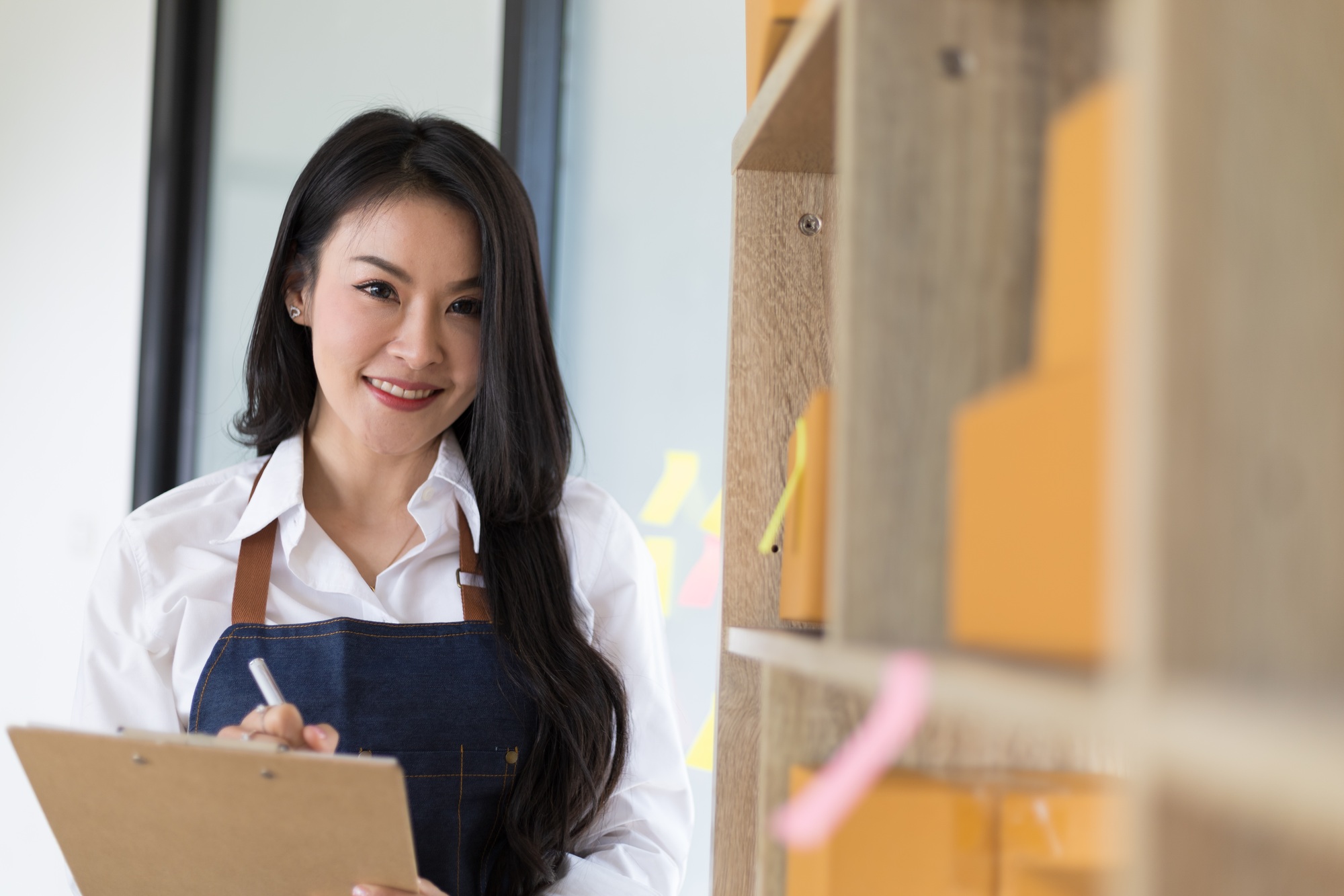 Woman small start-up online business owners write records and check lists of orders and merchandise.