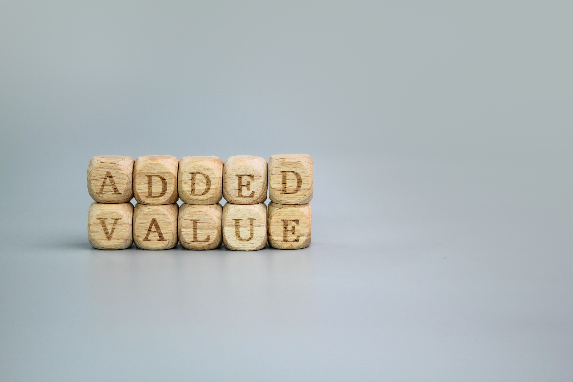 wooden cube with the word Added Value.