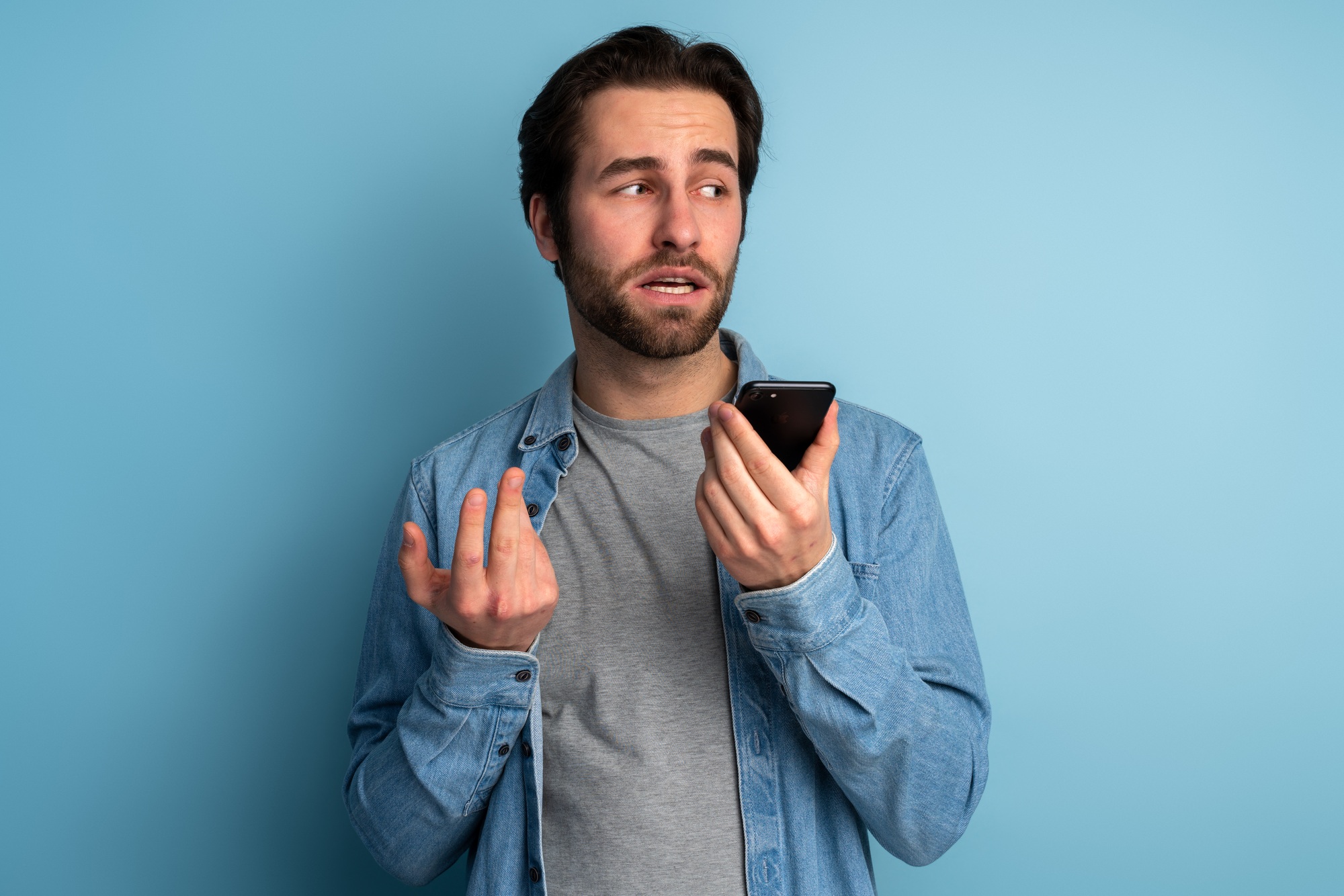 Young man using voice command recorder or calling on smartphone