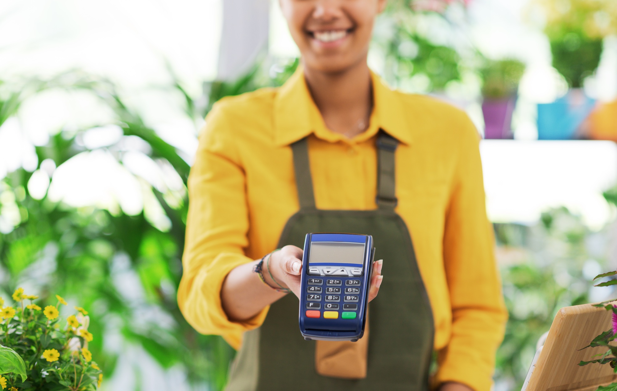 Smiling florist holding a POS terminal