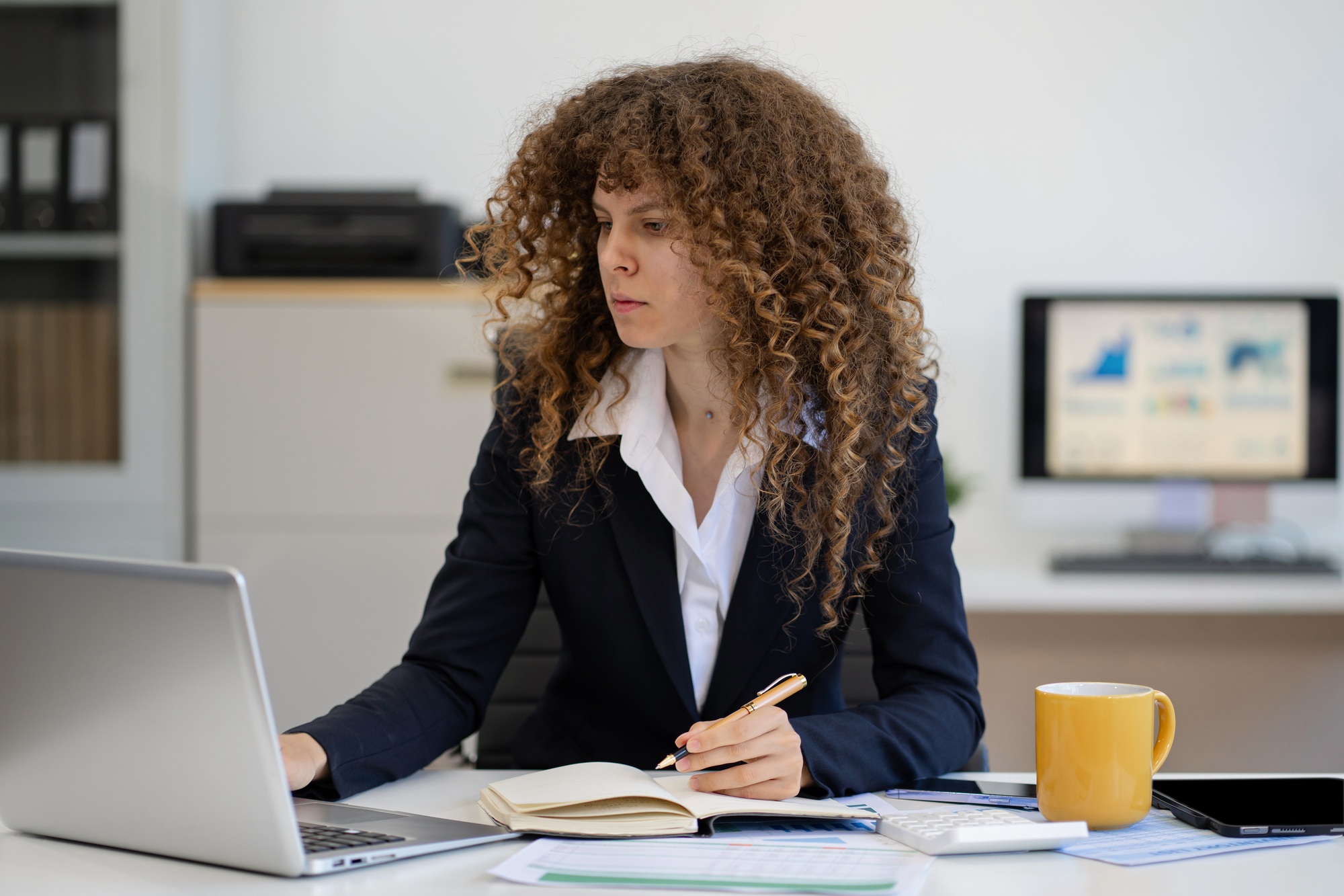 Business woman strategizing Ideas in a notebook, creative workspace.