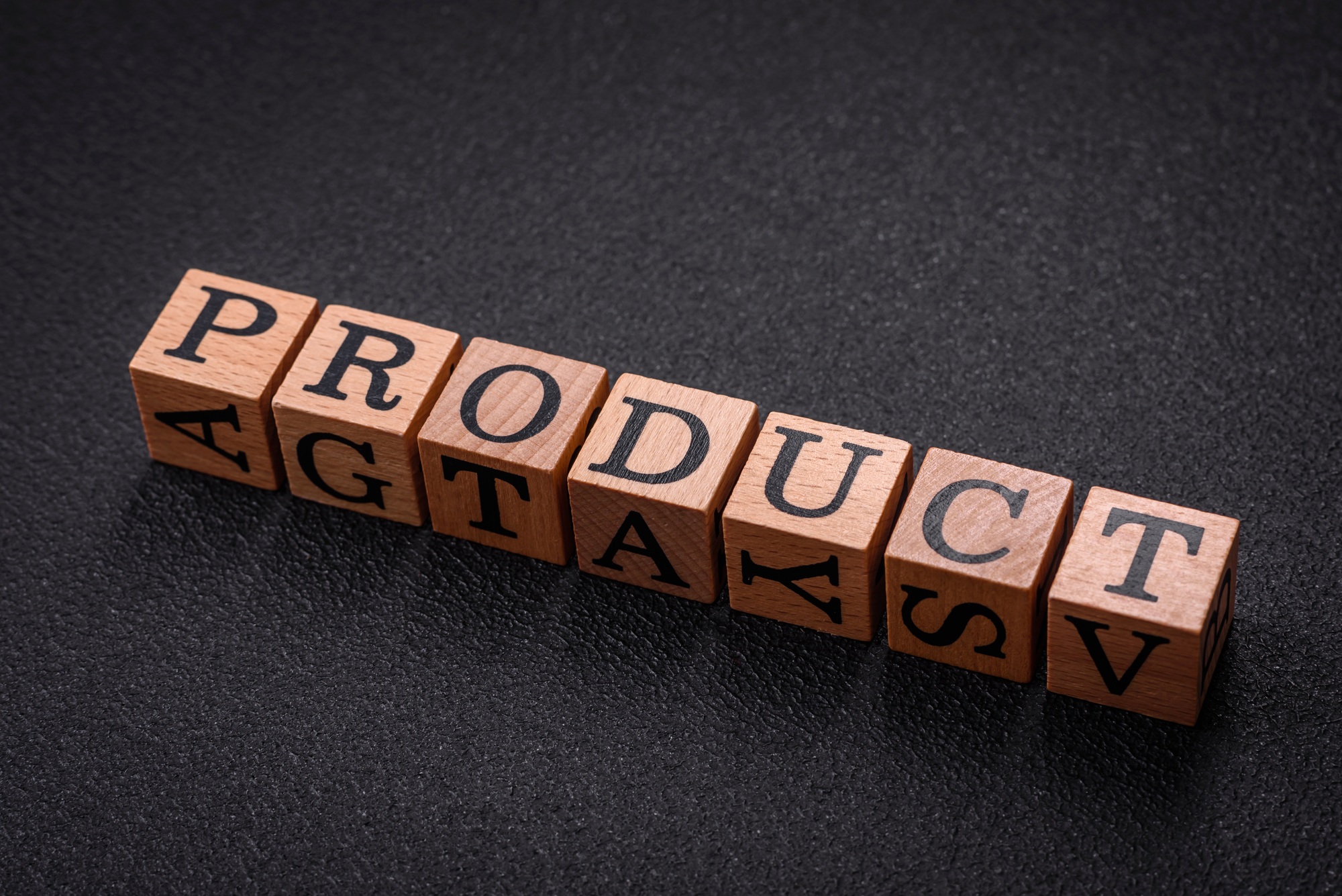 The inscription product with wooden cubes on a dark concrete background