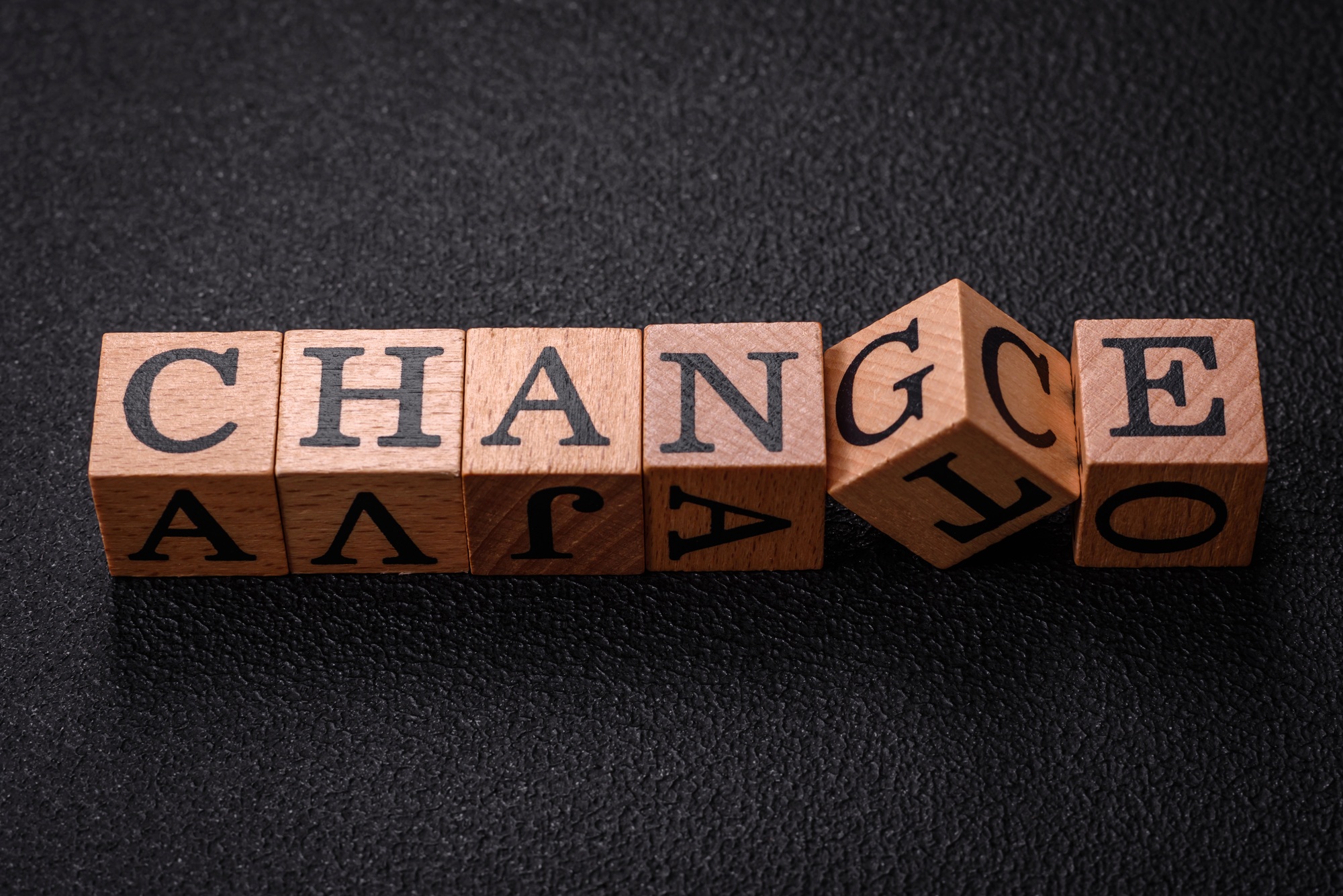 The inscription chance or change with wooden cubes on a dark concrete background