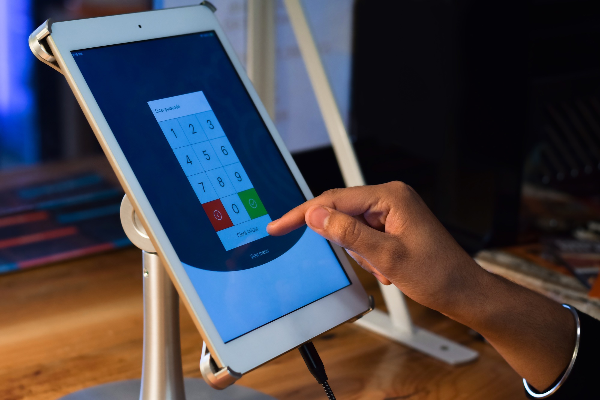 Restaurant employee hand using POS point of sale system on digital tablet password screen to login