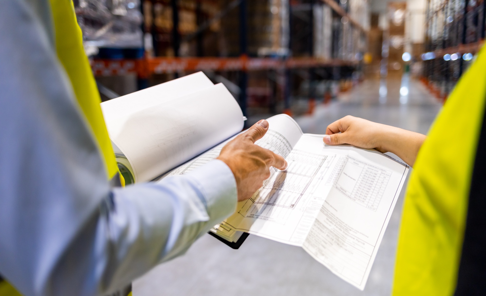 Warehouse workers checking inventory with plans in hand