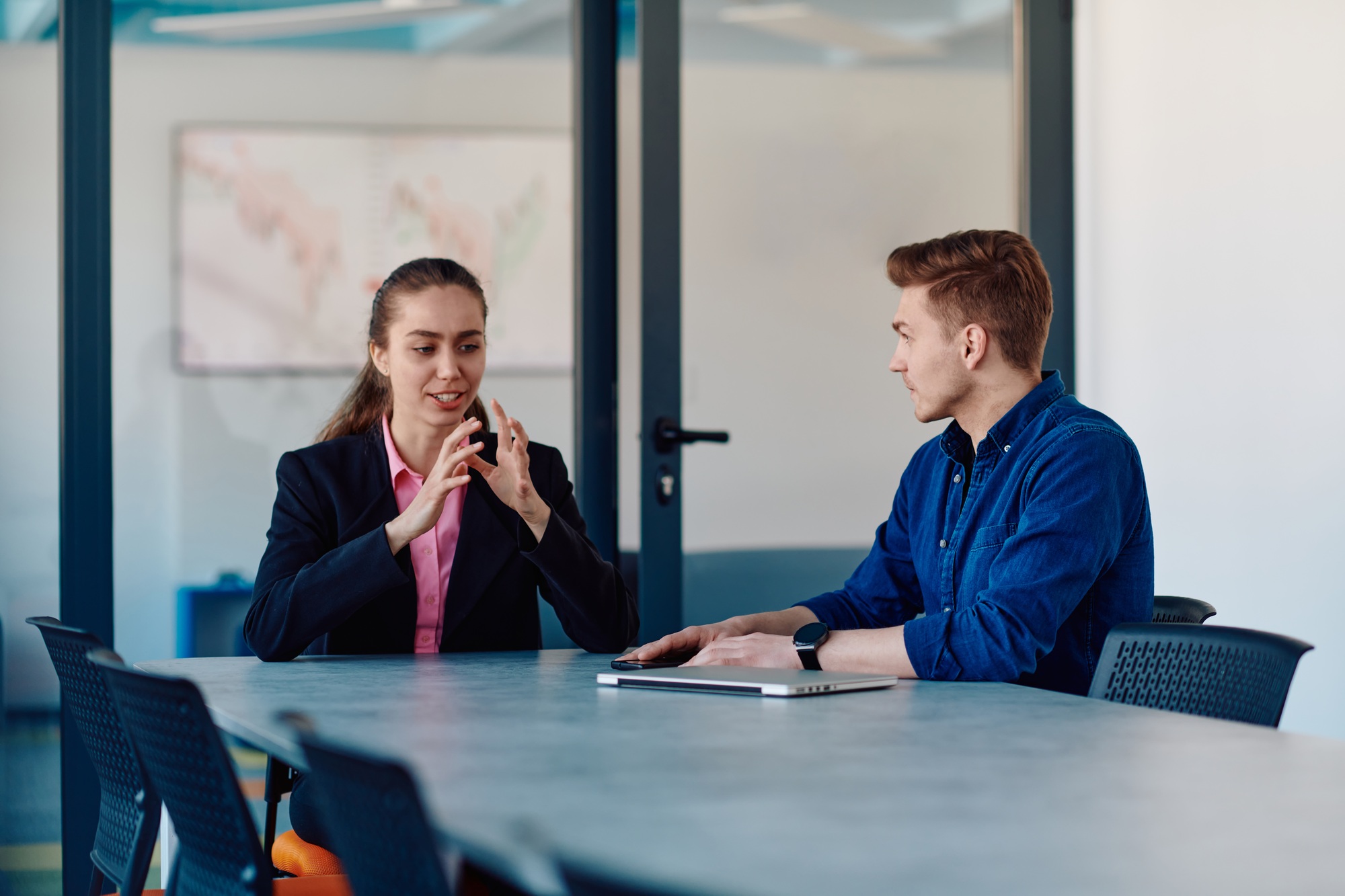 A business leader in a suit conversing with her worker in the IT industry about new business