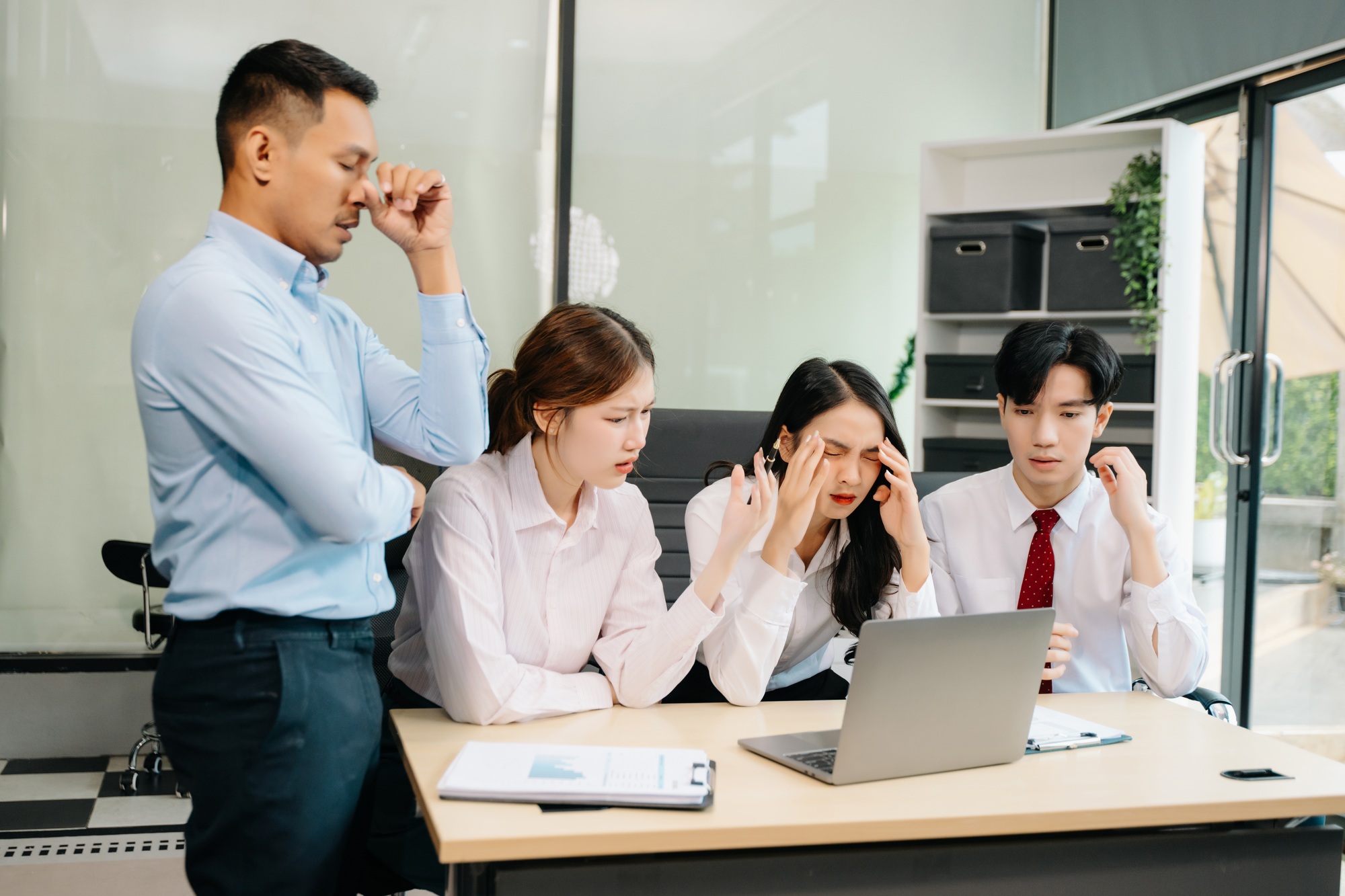A business team in a tense meeting, dealing with stress and frustration facing a challenging