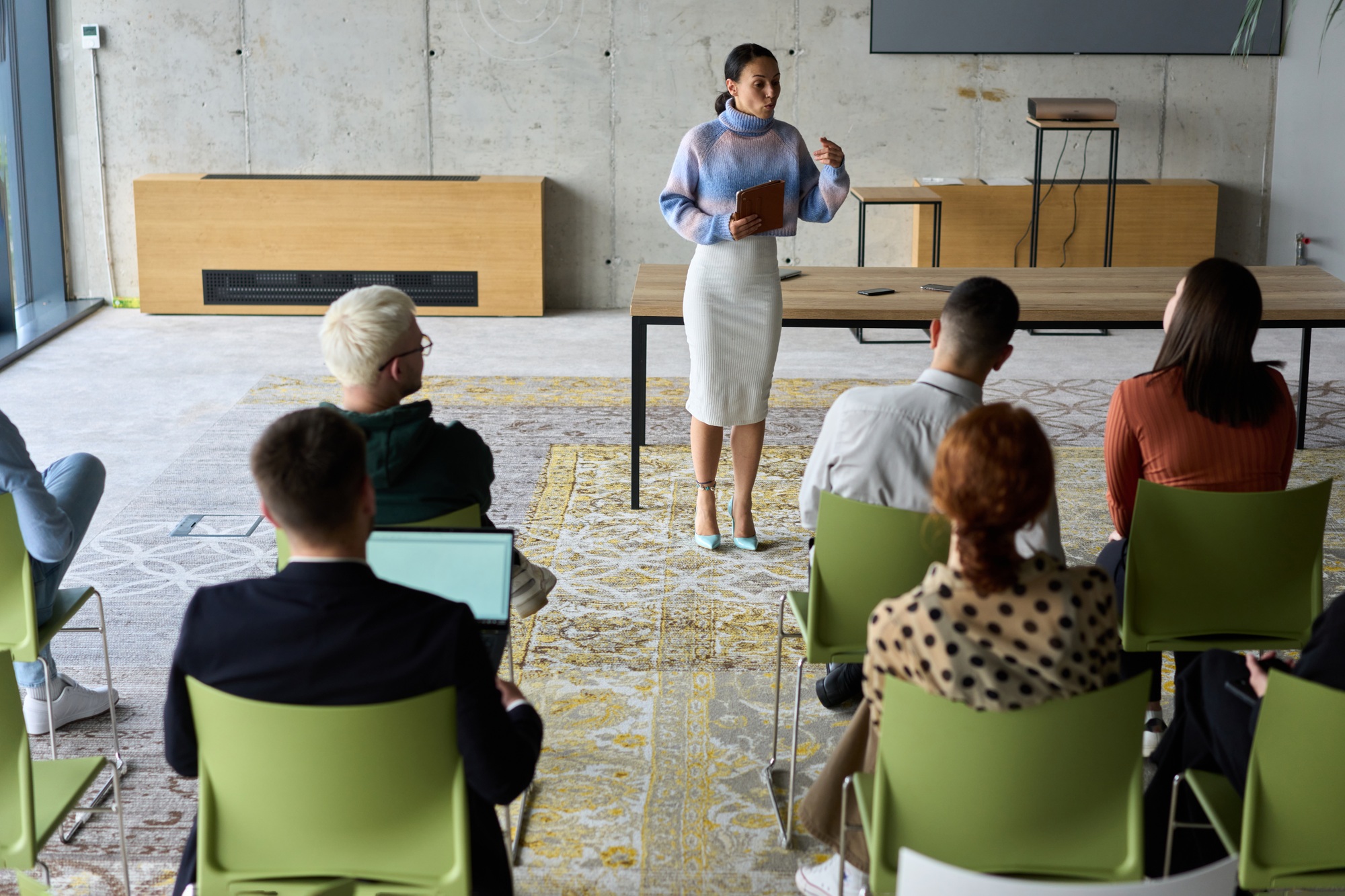 A businesswoman leader guiding a meeting with her colleagues, discussing business challenges