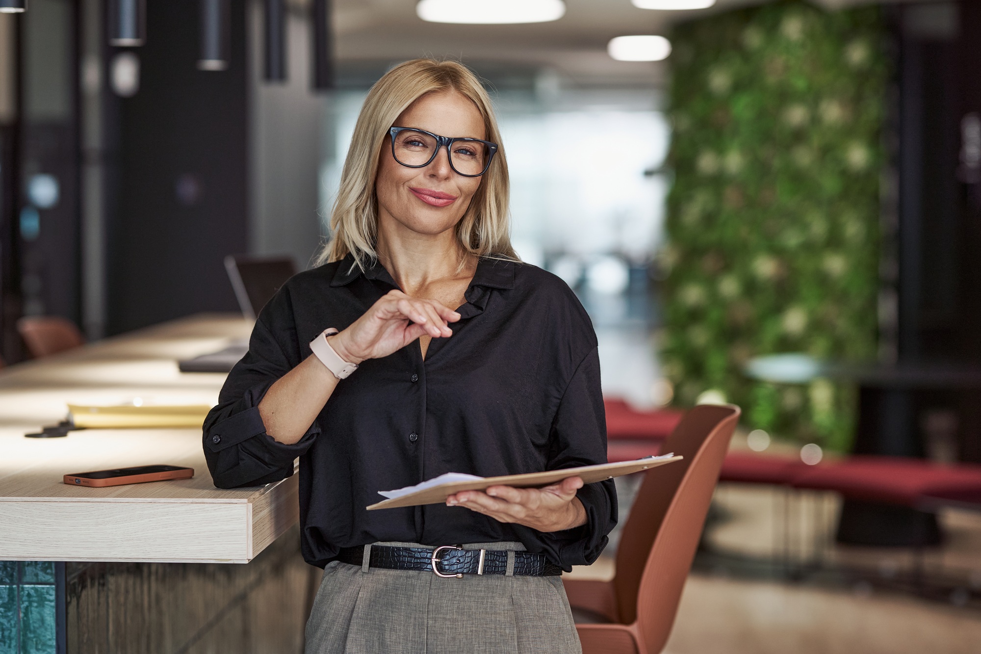 A confident businesswoman in a modern office, demonstrating her leadership and professionalism