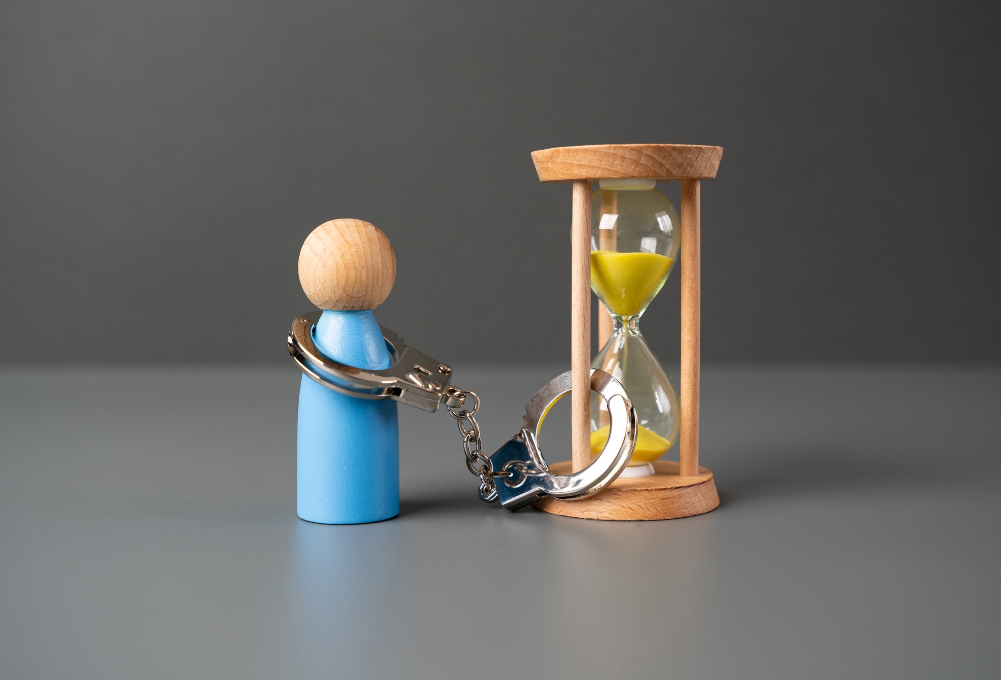 A man is handcuffed to an hourglass. T