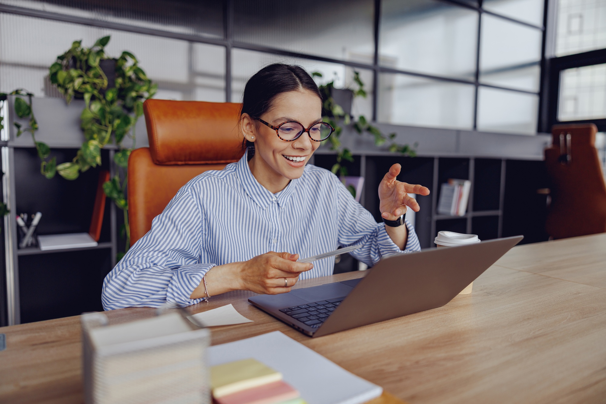 A Professional Woman Participating in an Online Meeting Set in a Modern Office Environment