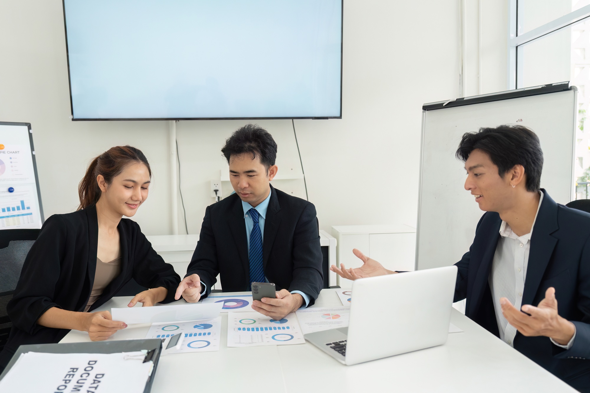 A team analyzing project data and strategizing solutions in a meeting room.