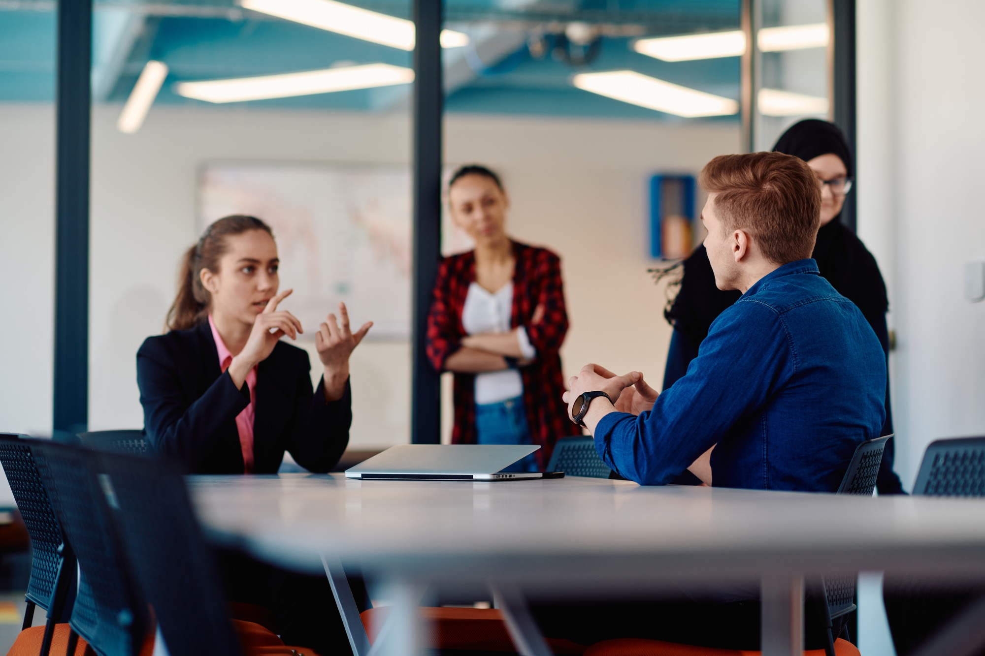 A team of successful programmers sits in a startup office, strategizing new business projects and