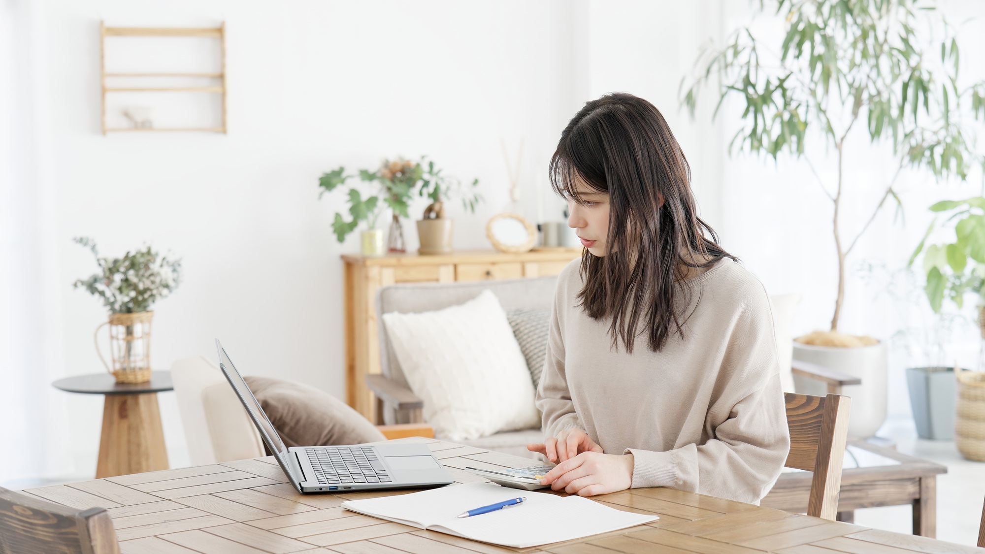 A woman calculating with a calculator and taking notes