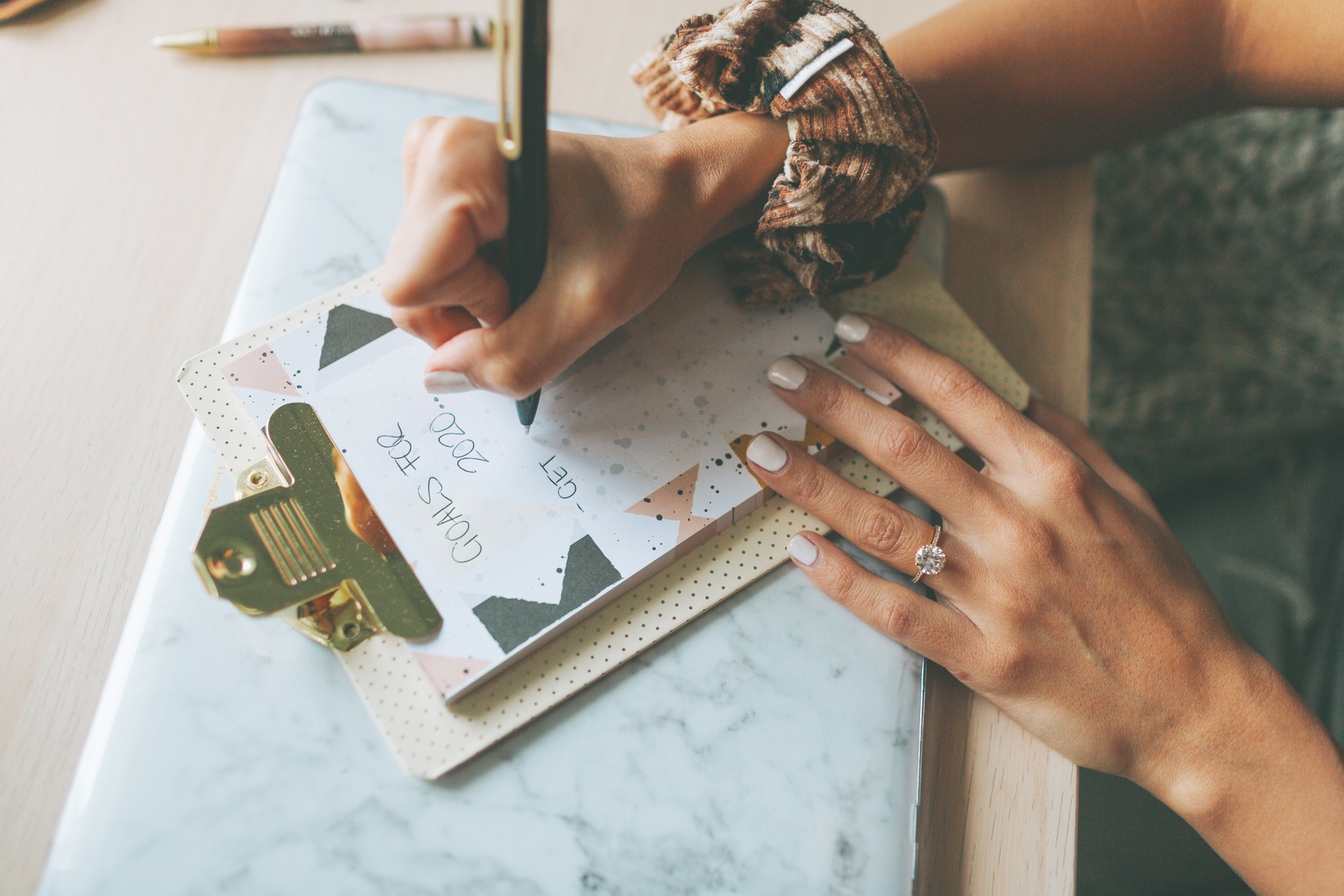 A woman writing a list of goals for the new year.