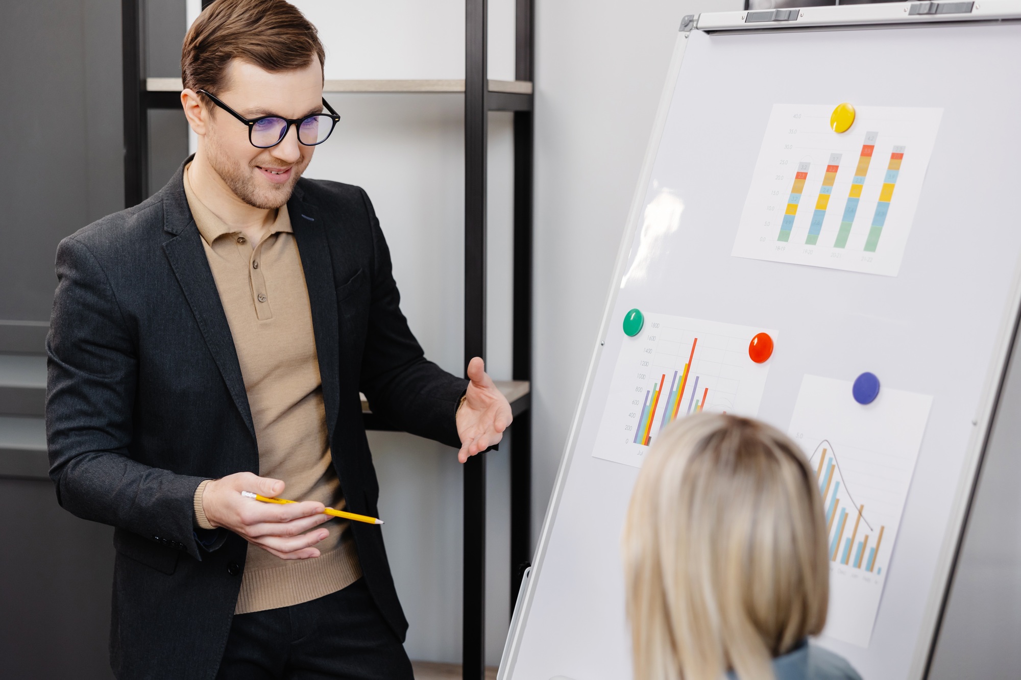 A young woman and a man are talking and discussing business project schedules in the office