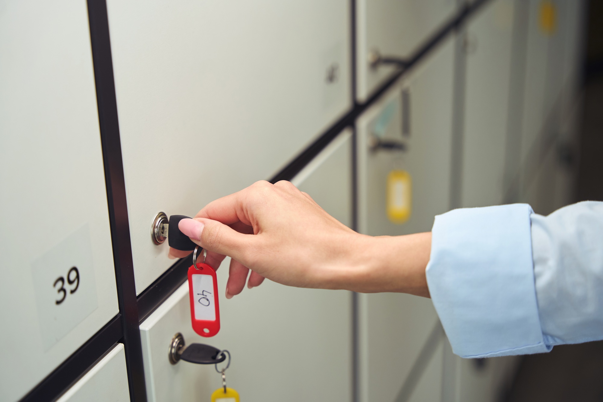 Adult person opening closed storage locker cabinet door