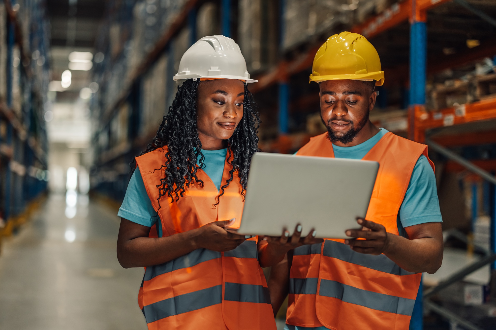 African american warehouse partners using laptop for planning
