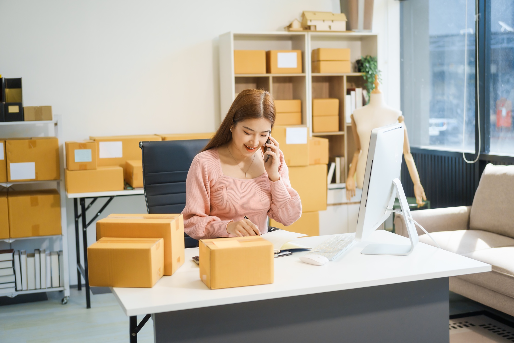 An Asian businesswoman sits at her desk, working on online sales  e-commerce marketing strategies