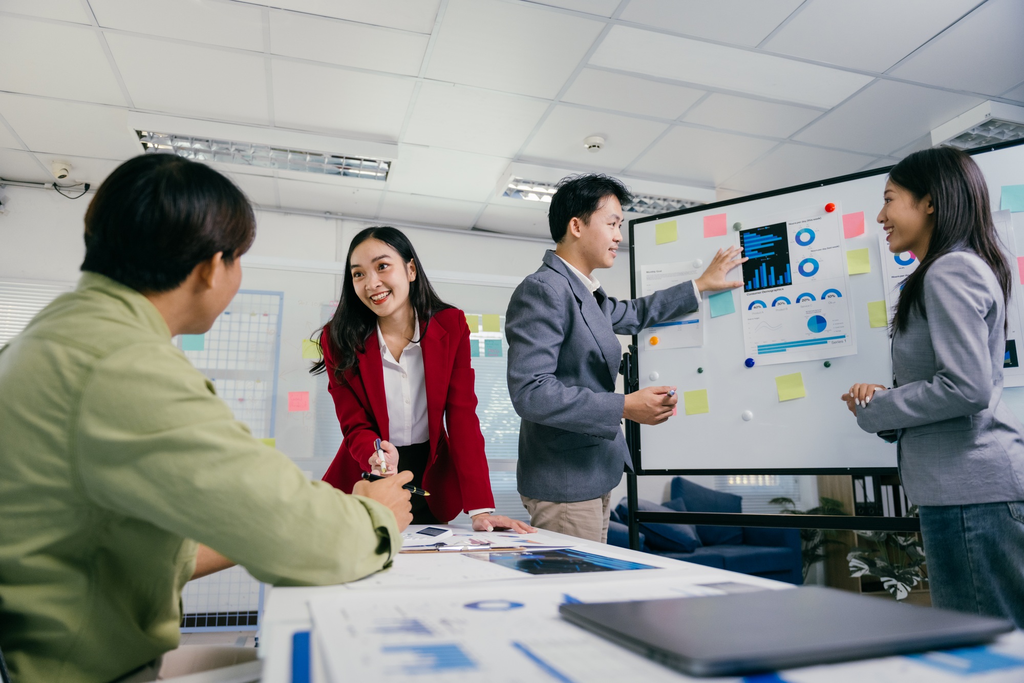 Asian businesspeople discussing charts and statistics during meeting