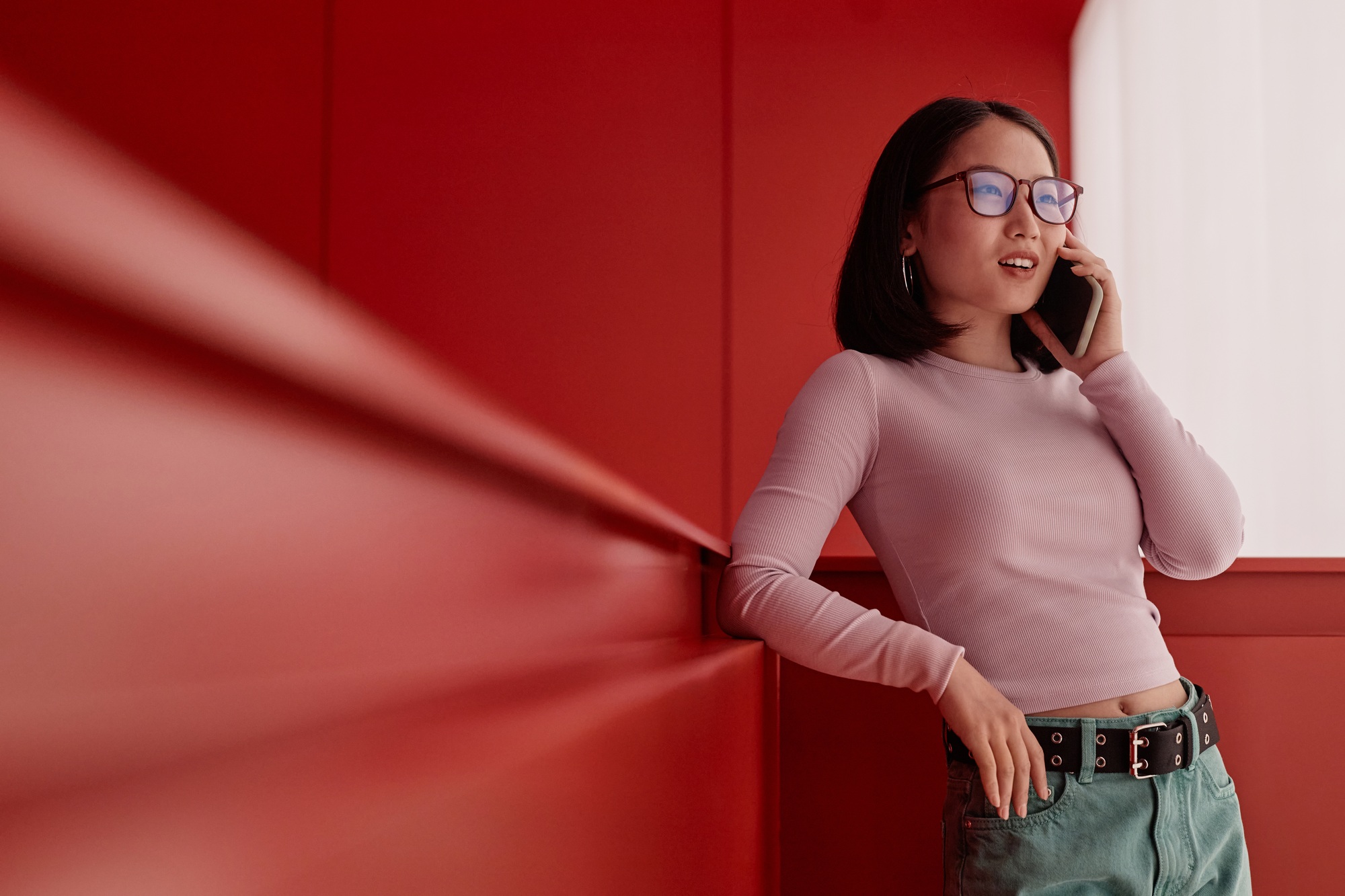 Asian Businesswoman Speaking by Smartphone in Red Space