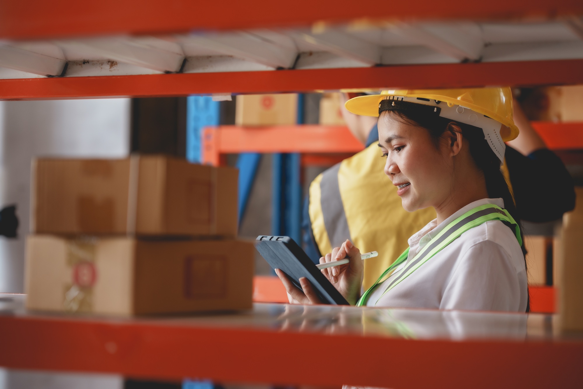 Asian female warehouse worker check and count inventory in the warehouse for accuracy