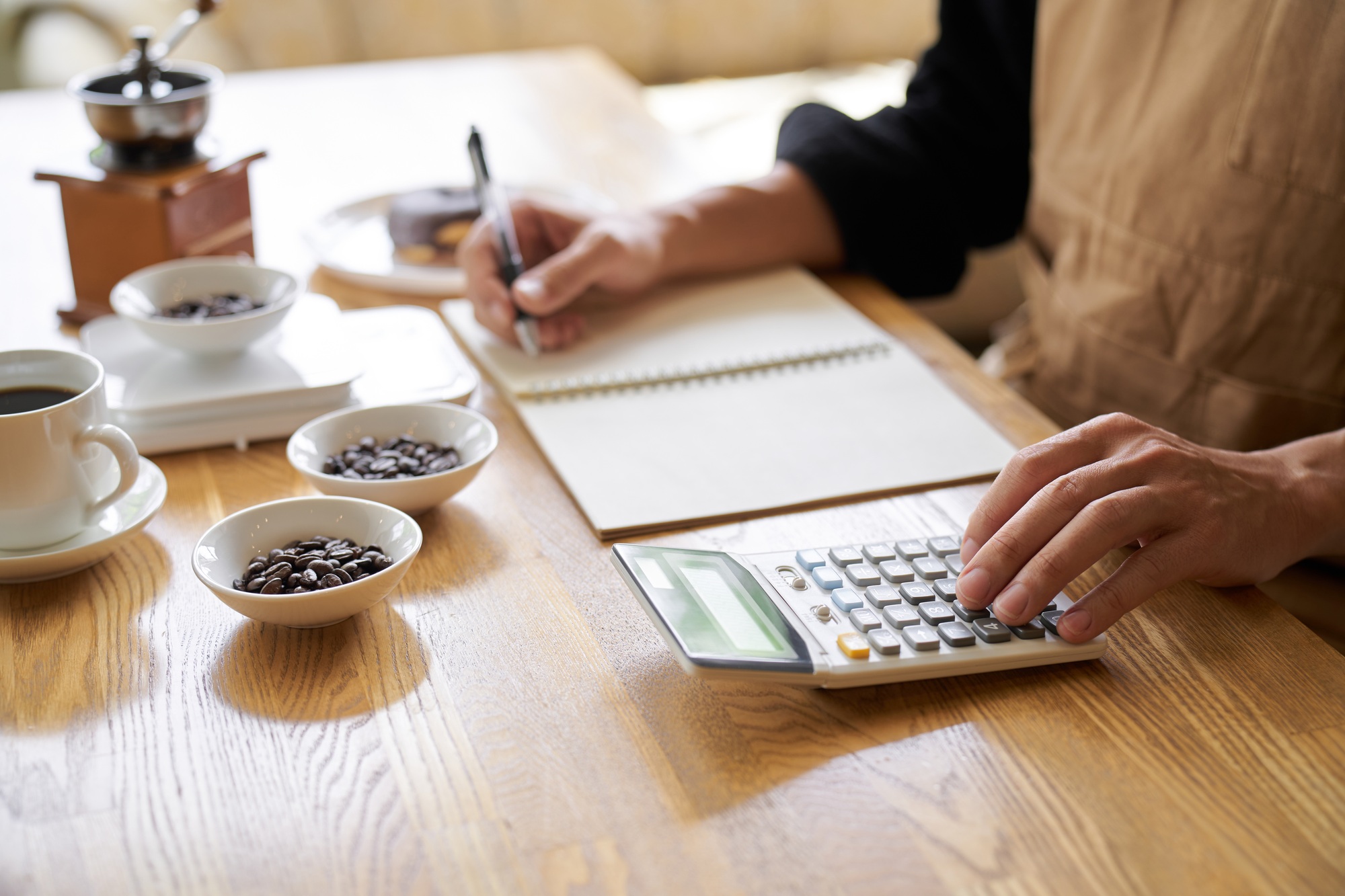 Asian man calculating the cost of coffee