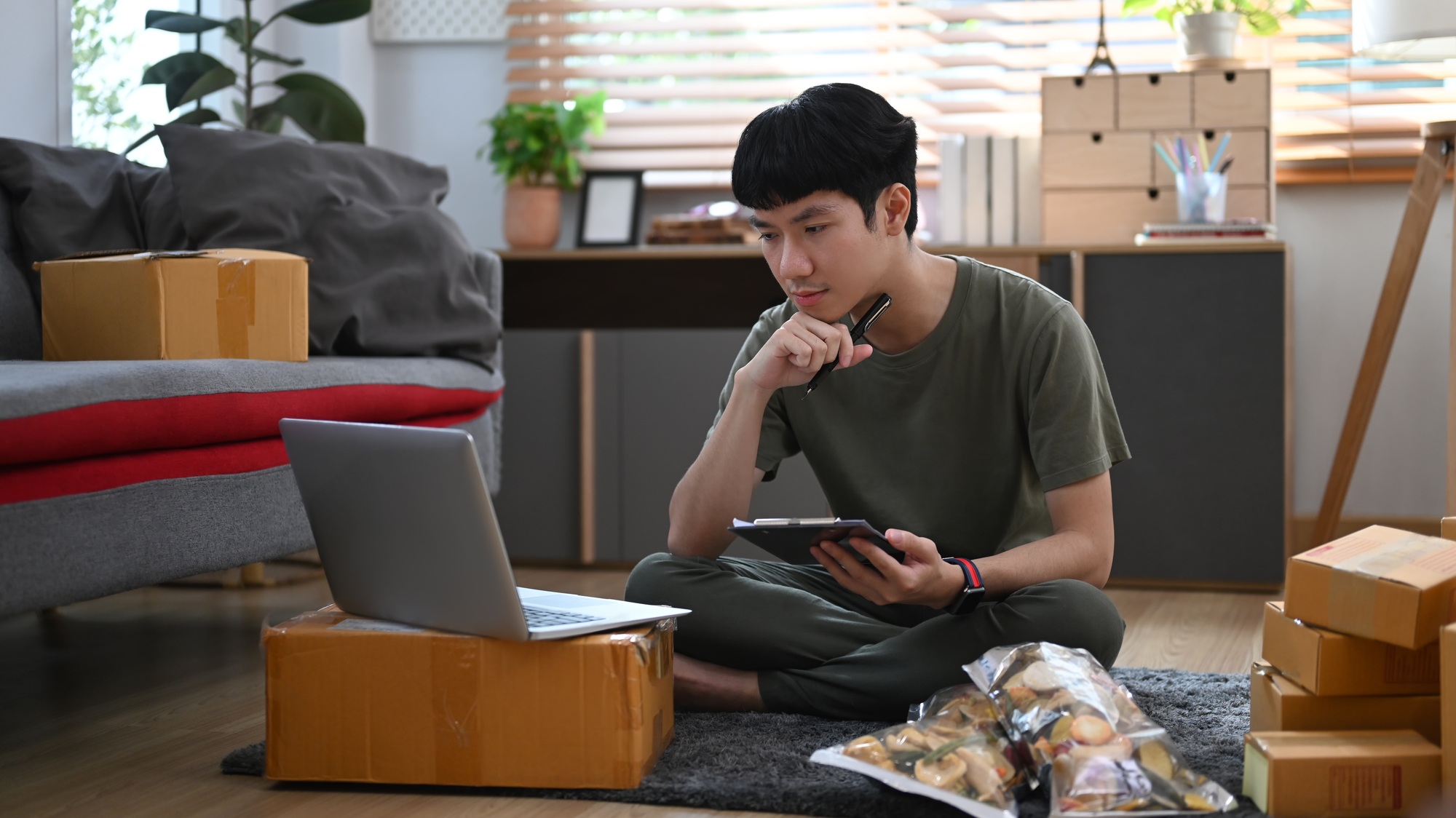 Asian man online seller checking product purchase order on laptop.