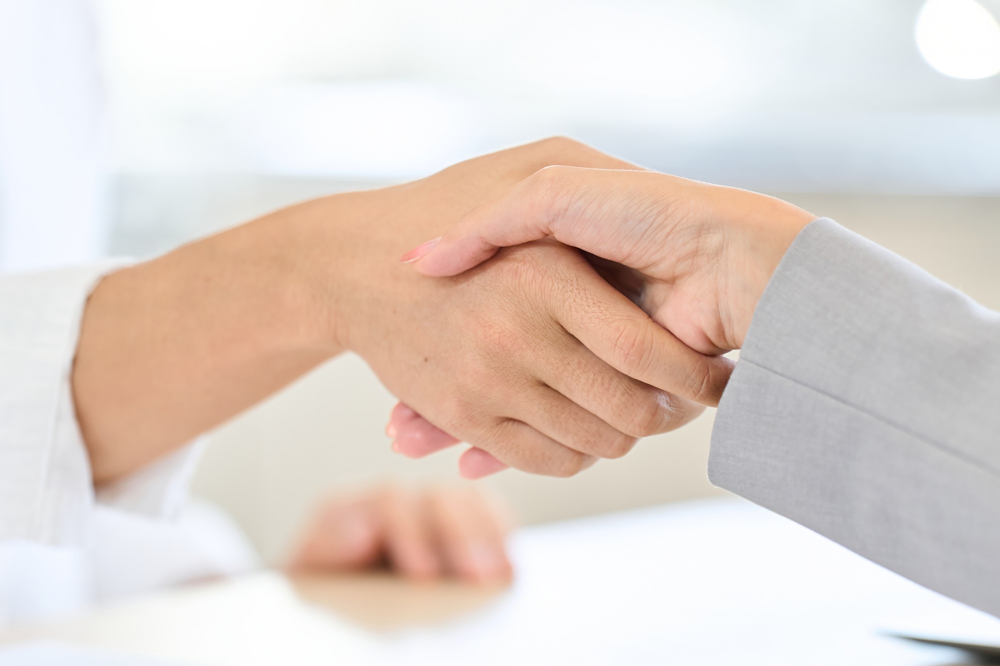 Asian man shaking hands with insurance contract